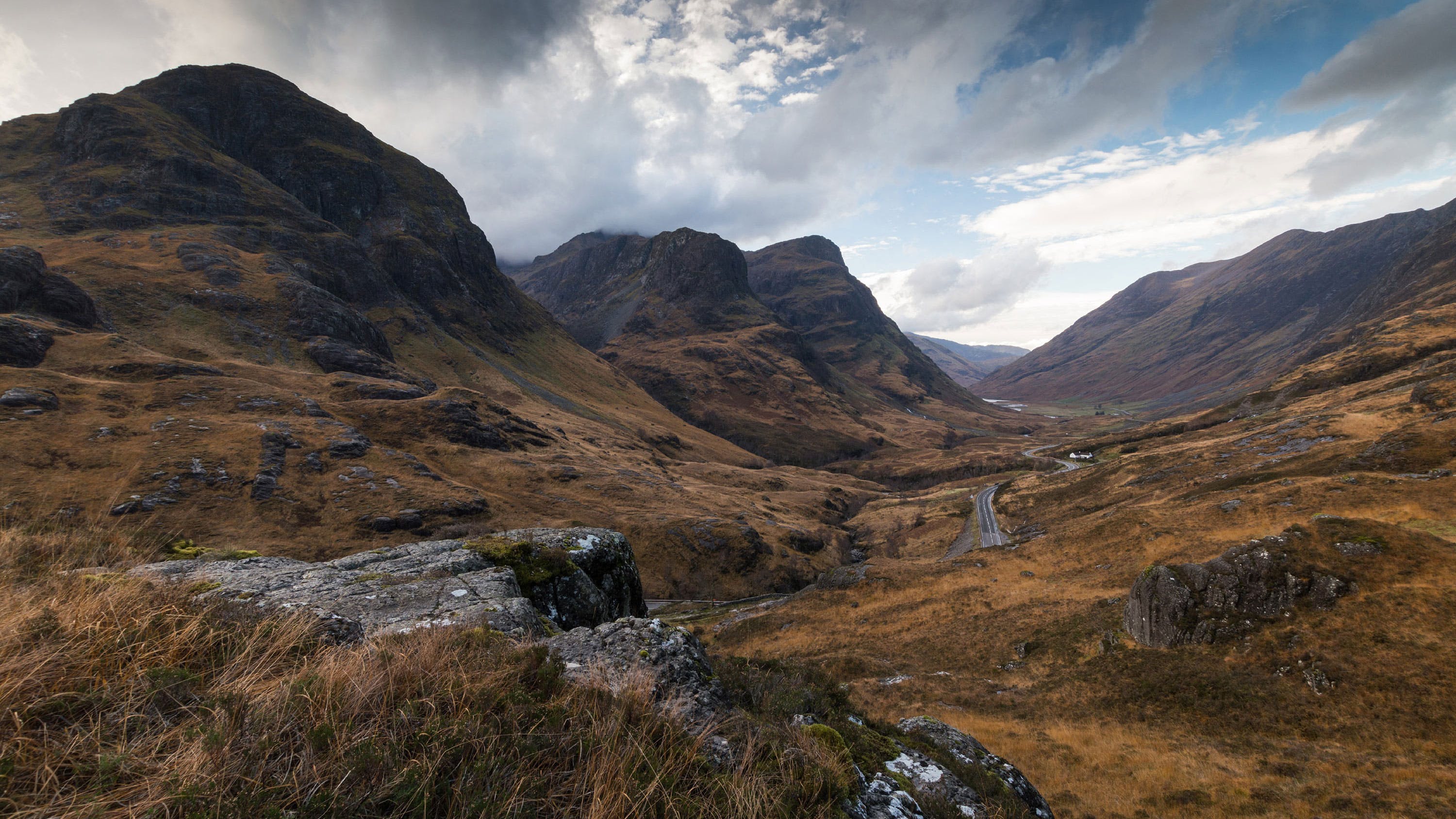 A scenic view of a valley with mountains in the background