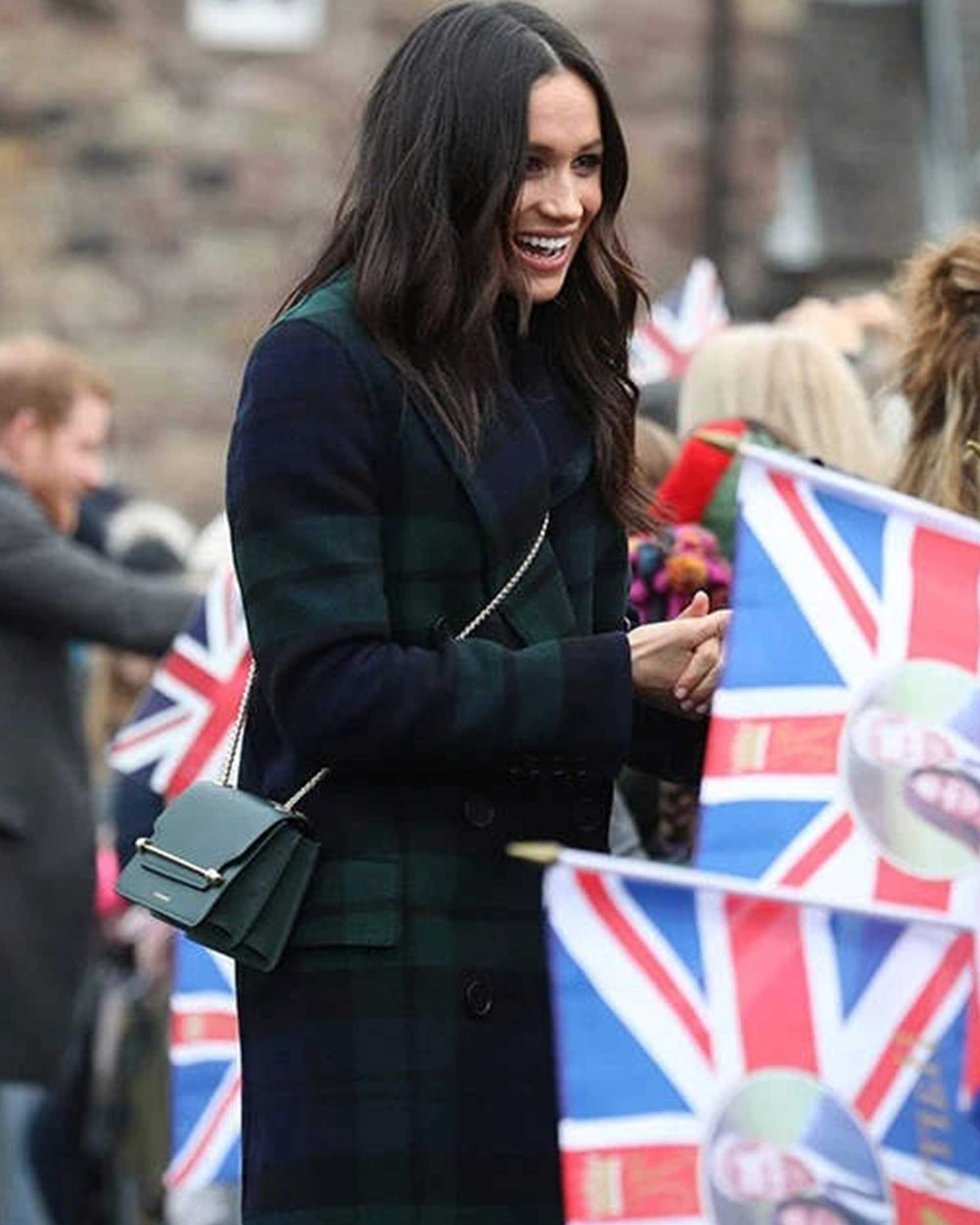 A woman in a black and green coat and a flag