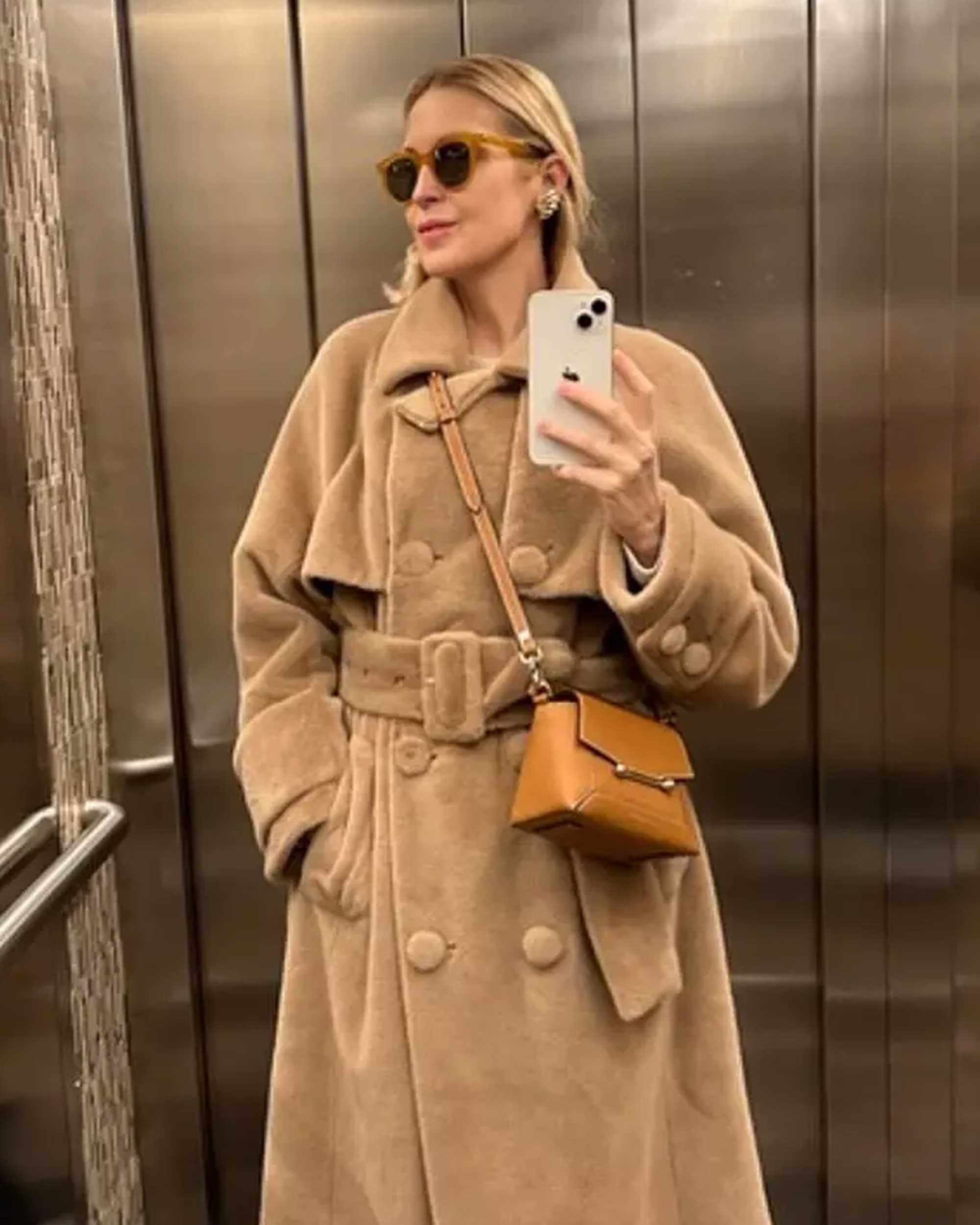 A woman taking a selfie in front of an elevator