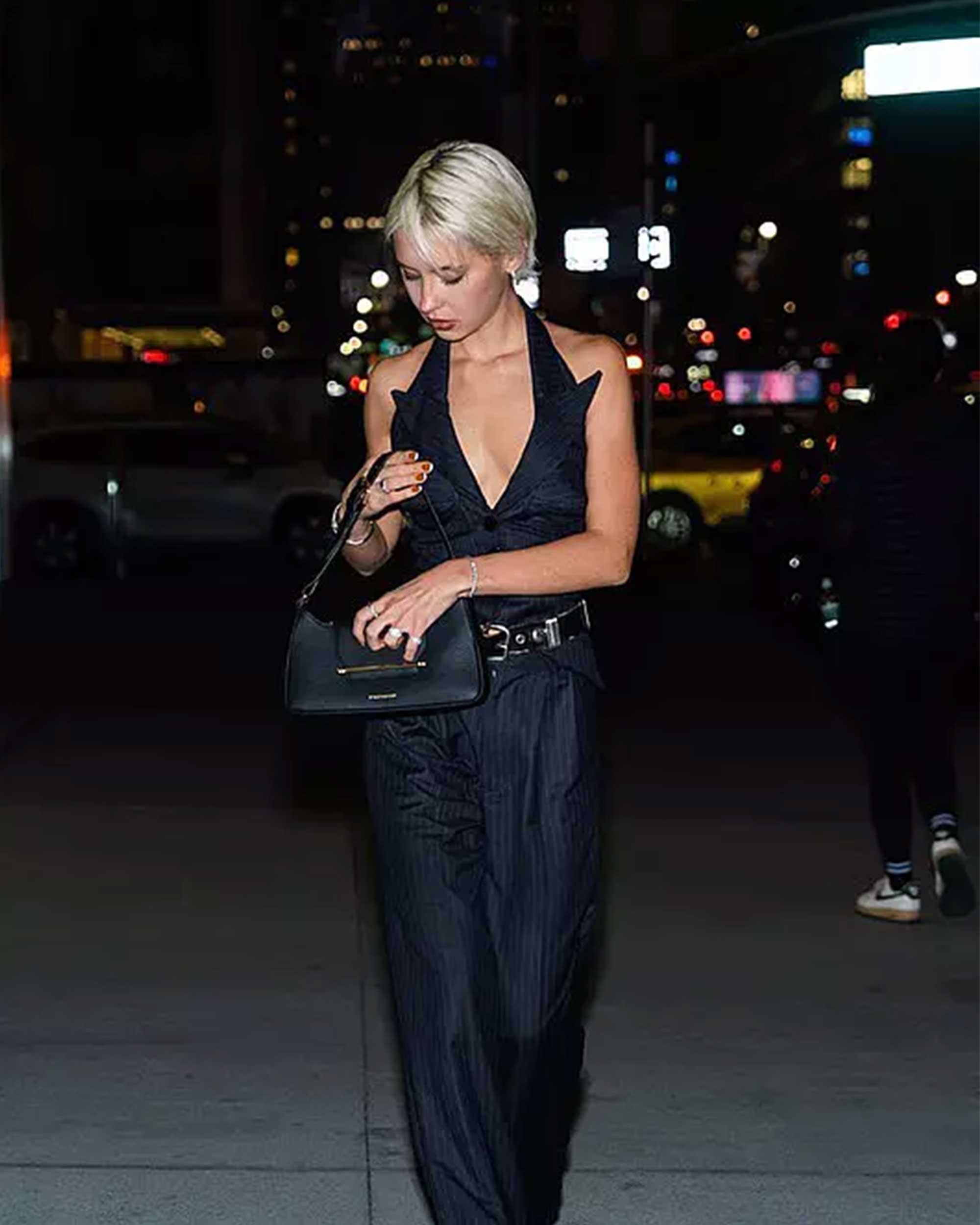 A woman walking down a street at night