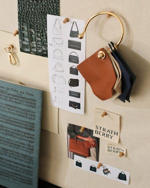 A purse hanging on a wall next to a book