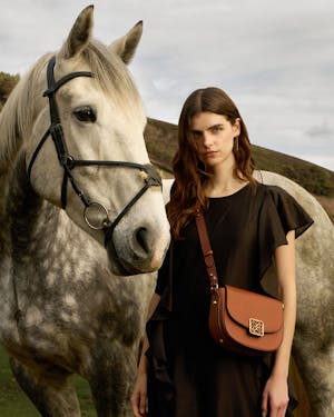 A woman standing next to a white horse