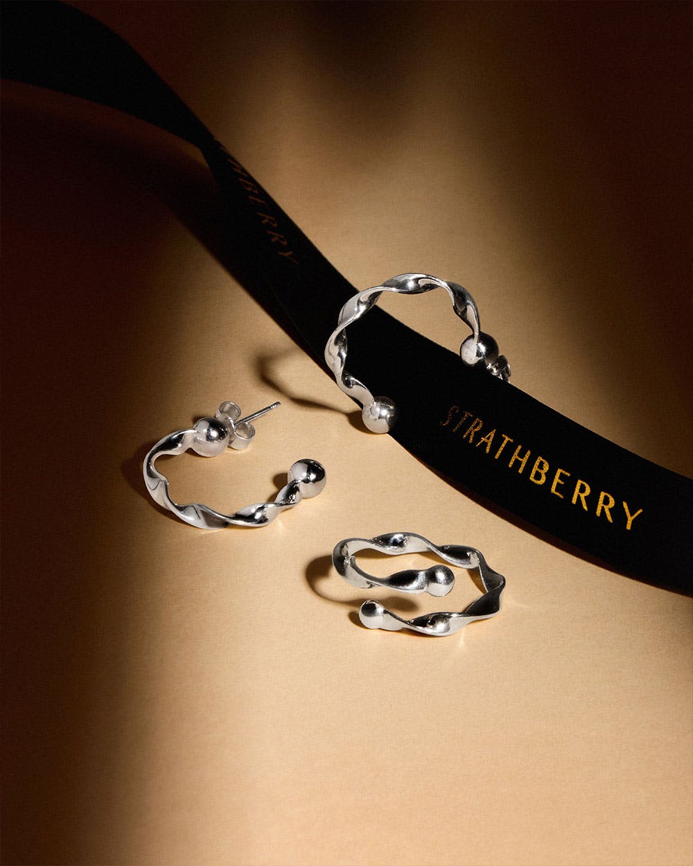 A pair of silver rings and a black ribbon