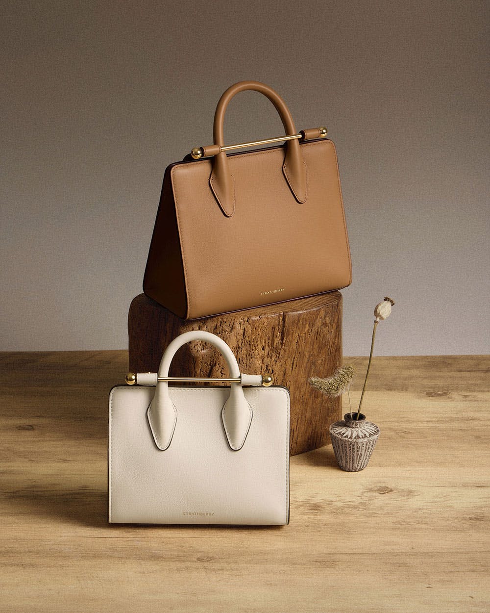 A brown and a white bag sitting on top of a wooden table