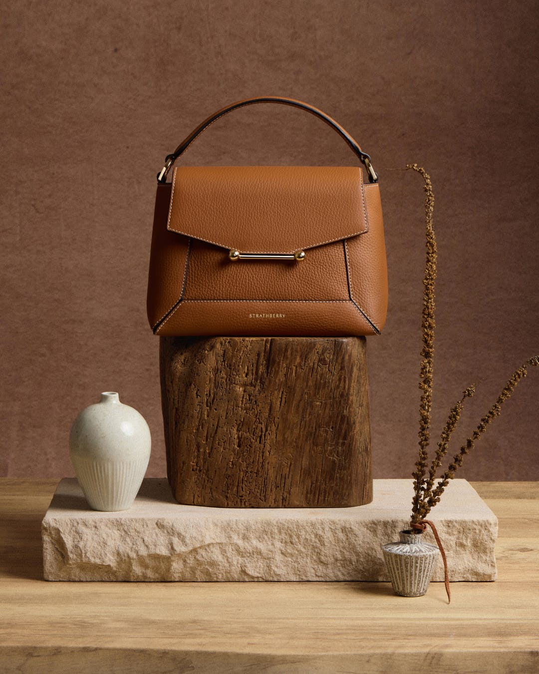 A brown purse sitting on top of a wooden block