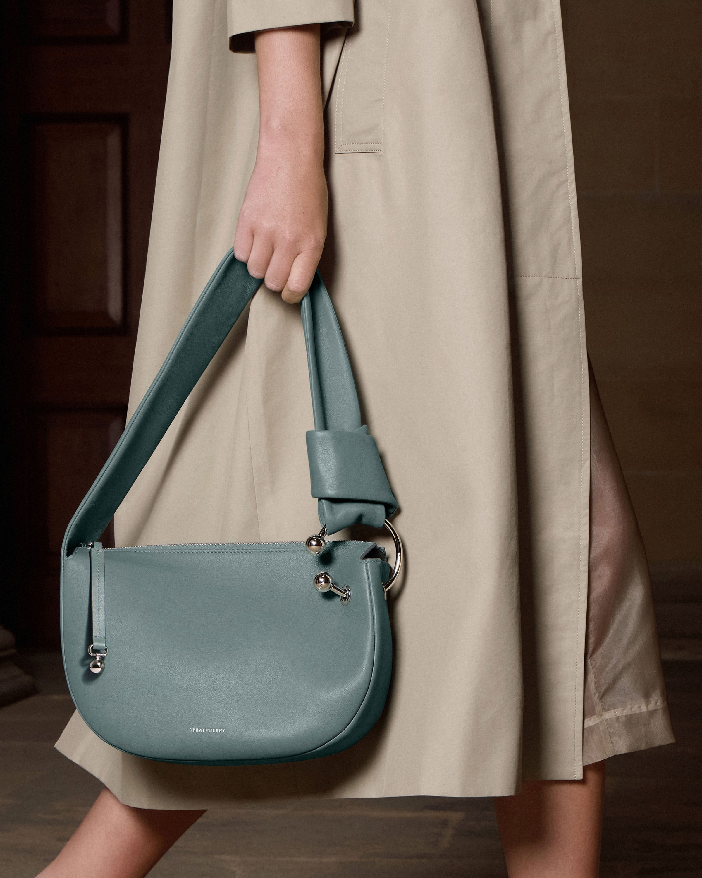 A woman carrying a blue purse on a wooden floor