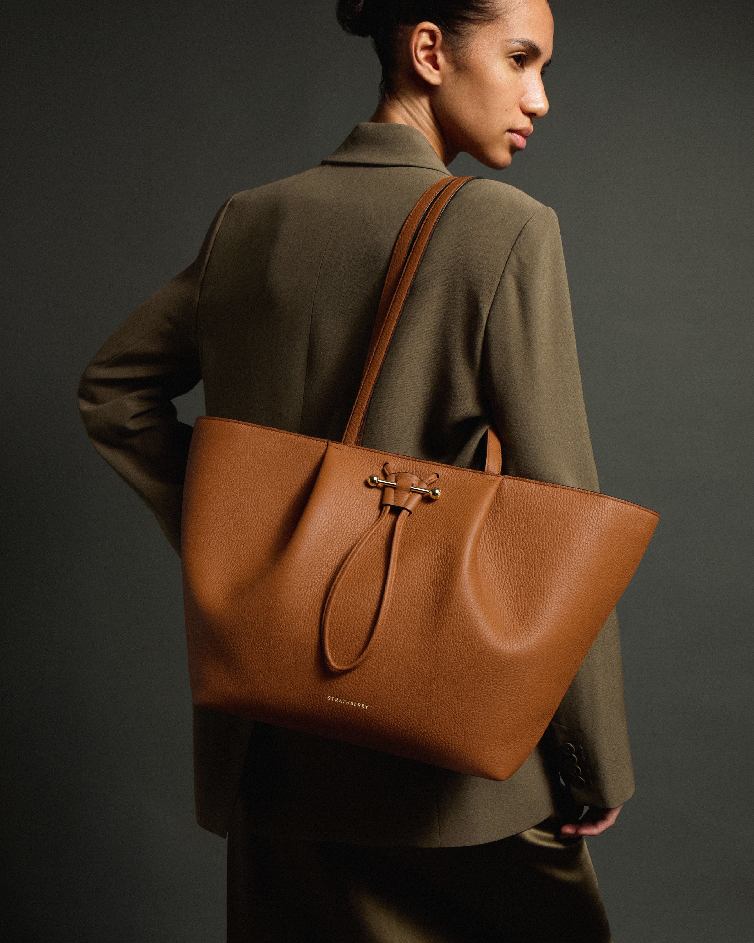 A woman carrying a brown purse on her back