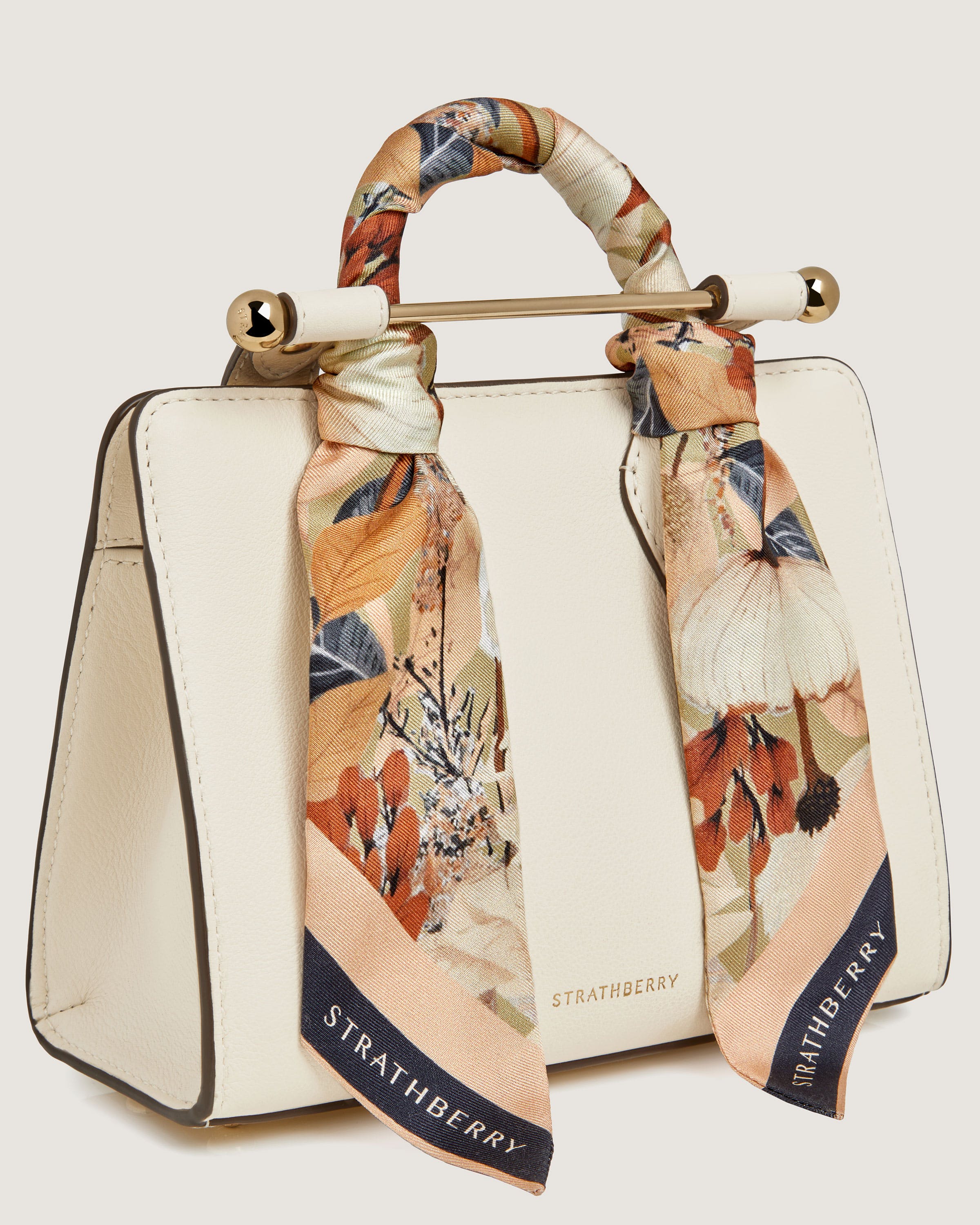 A white handbag with a floral print on it