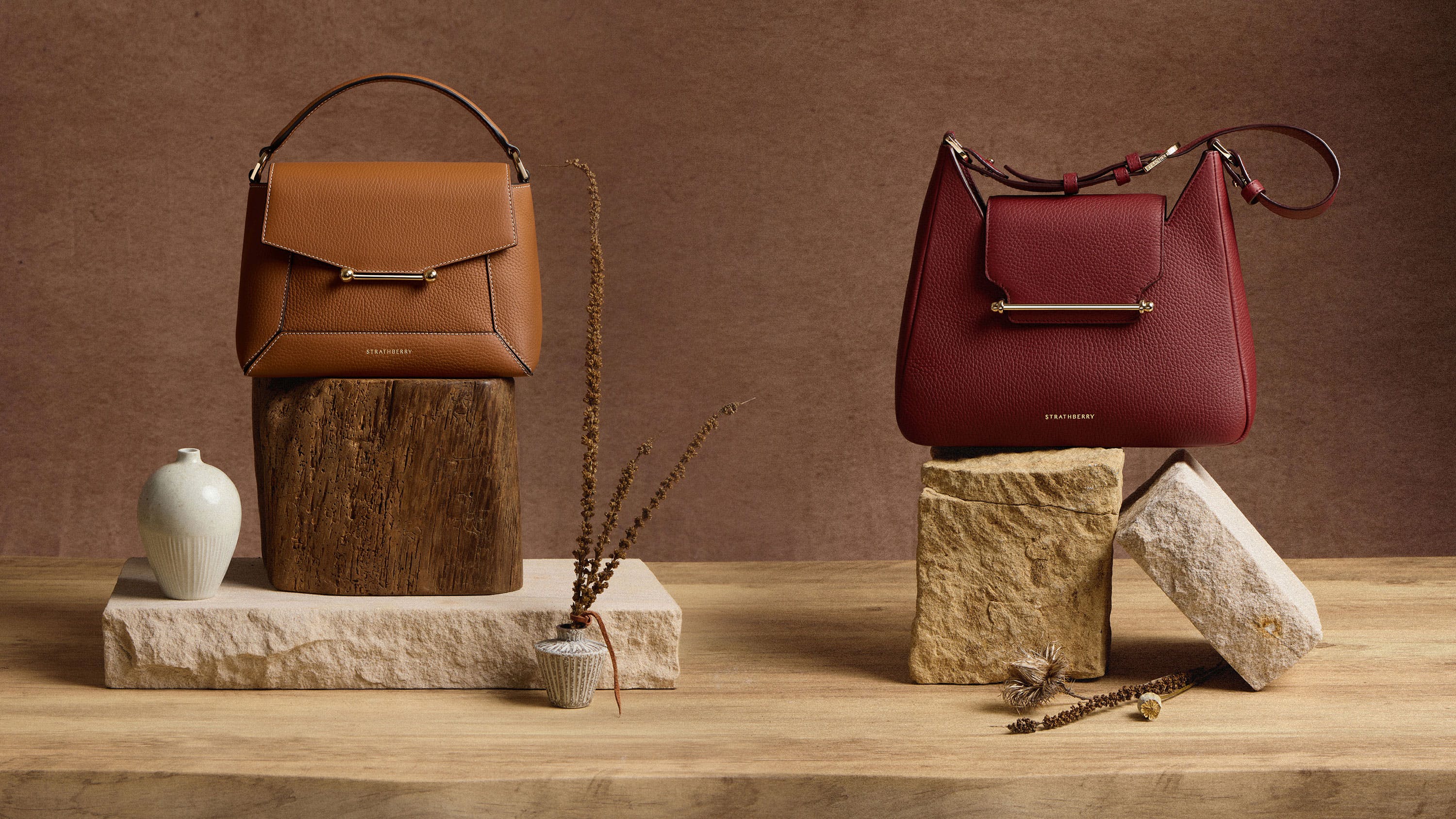 Three different purses sitting on top of a wooden table