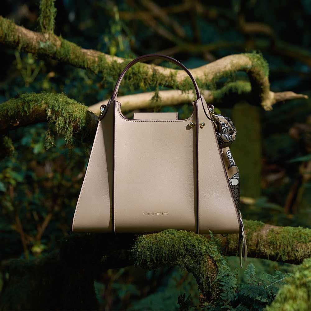 A white purse sitting on top of a tree branch