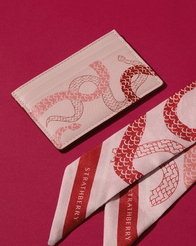 A pair of red and white ties sitting on top of a pink surface