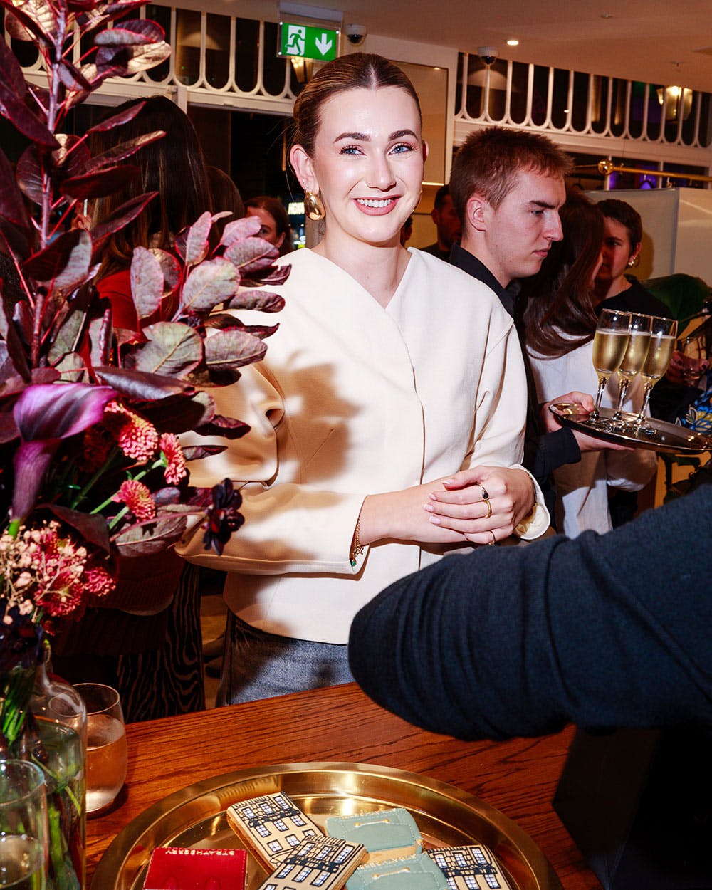 A woman standing in front of a cake on a table