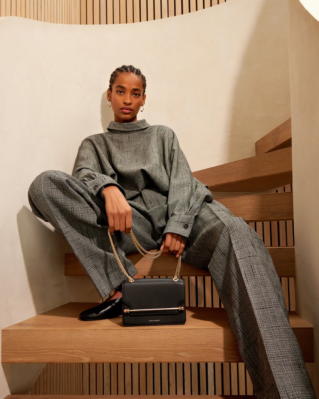 A woman sitting on a set of stairs with a handbag