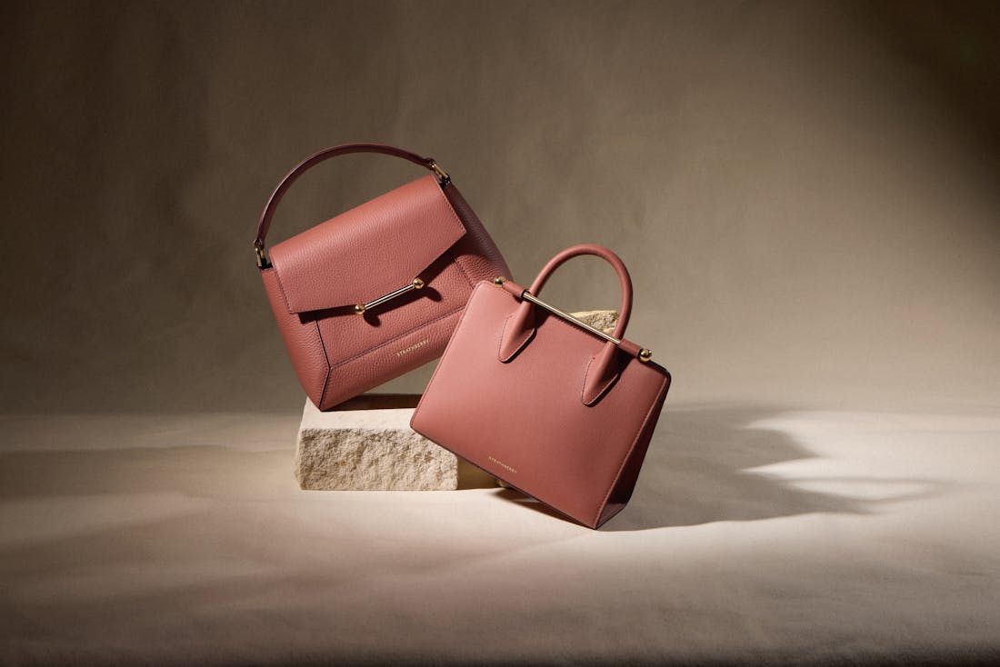 A pair of pink bags sitting on top of a wooden block