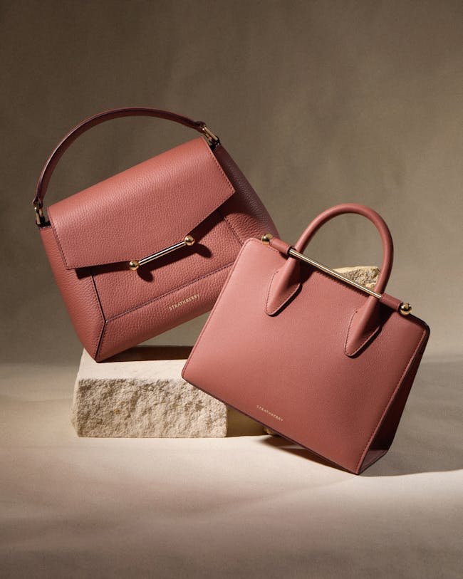 Two pink handbags sitting on top of each other