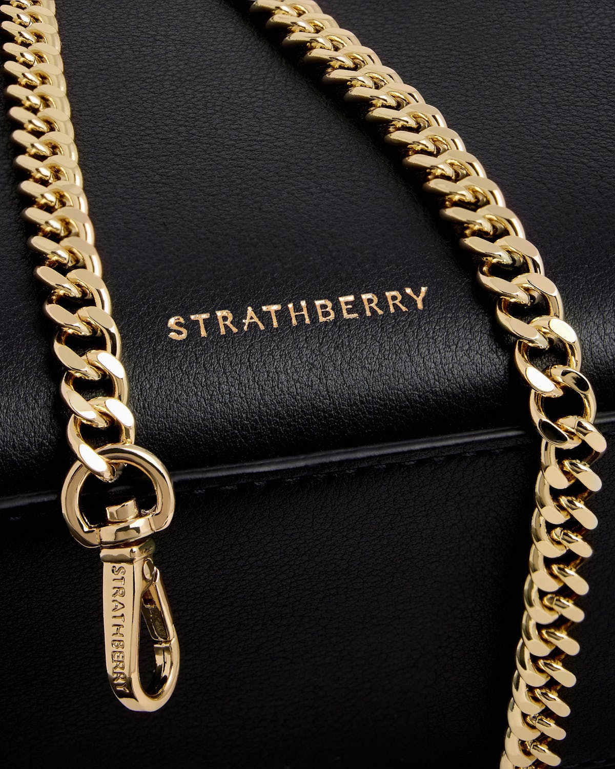 Strathberry nano tote black leather with gold chain detail.