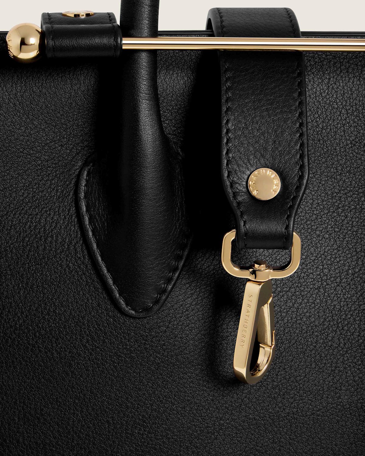 A close up of a black bag with a gold handle