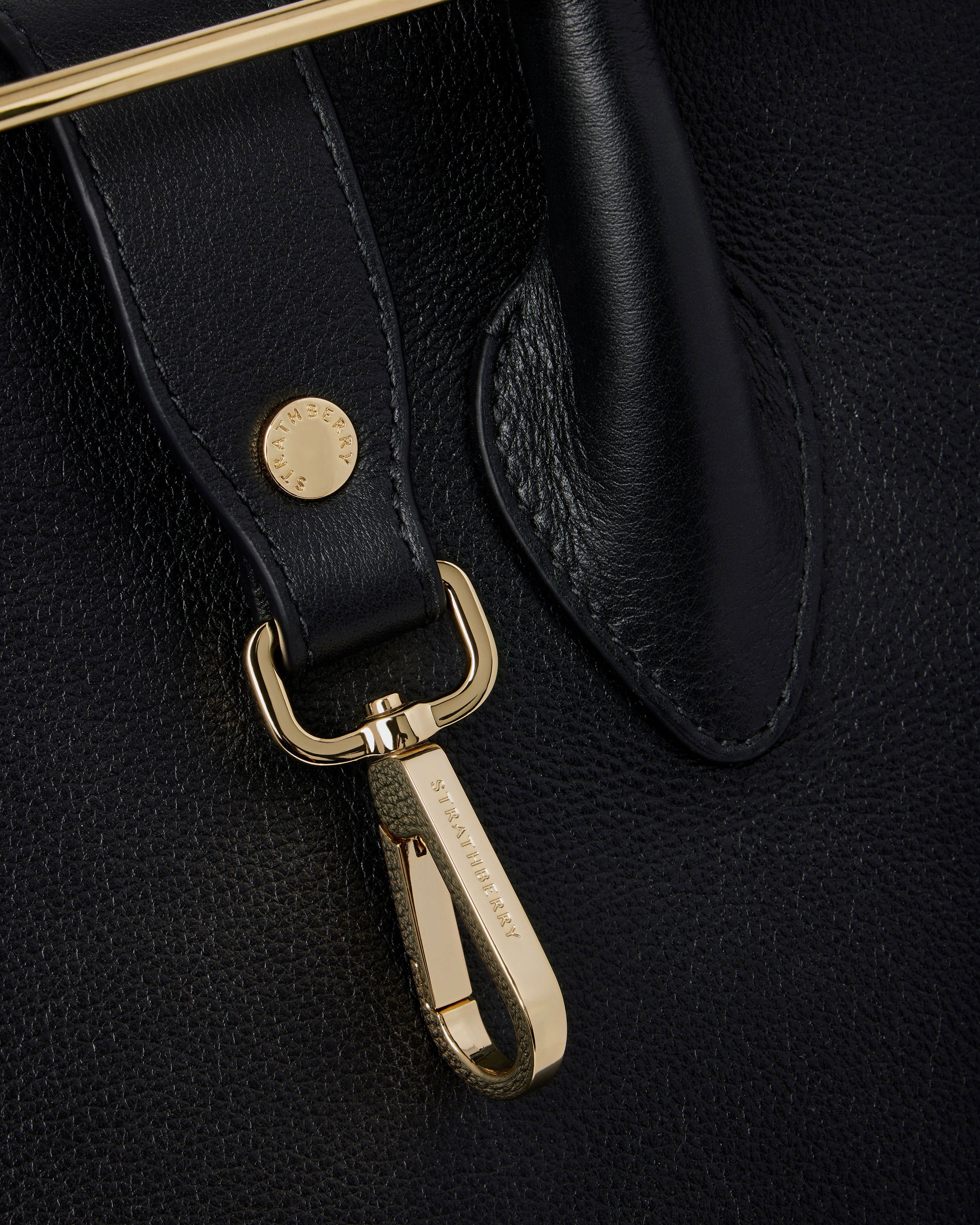 A close up of a black bag with a gold handle