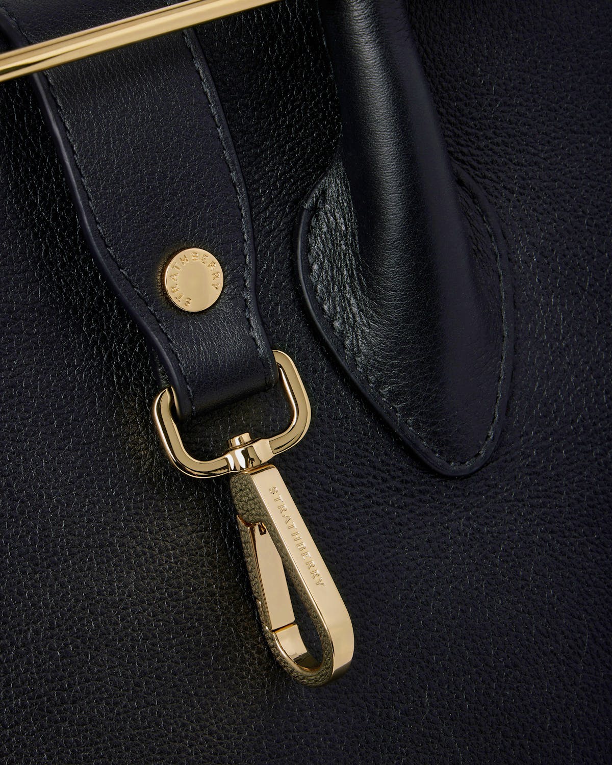 Black leather tote strap with gold clip hardware engraved Strathberry
