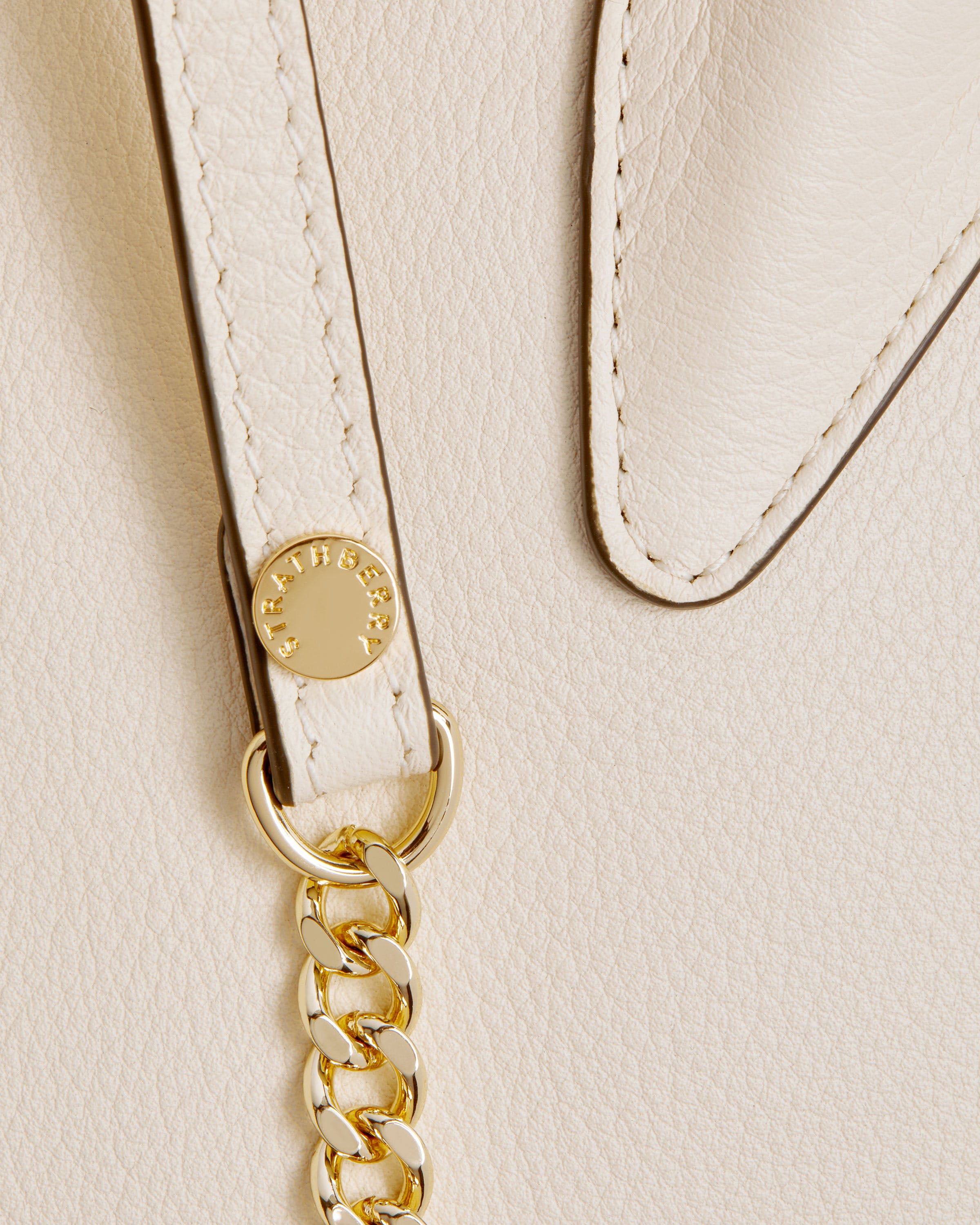 A close up of a white purse with a gold chain