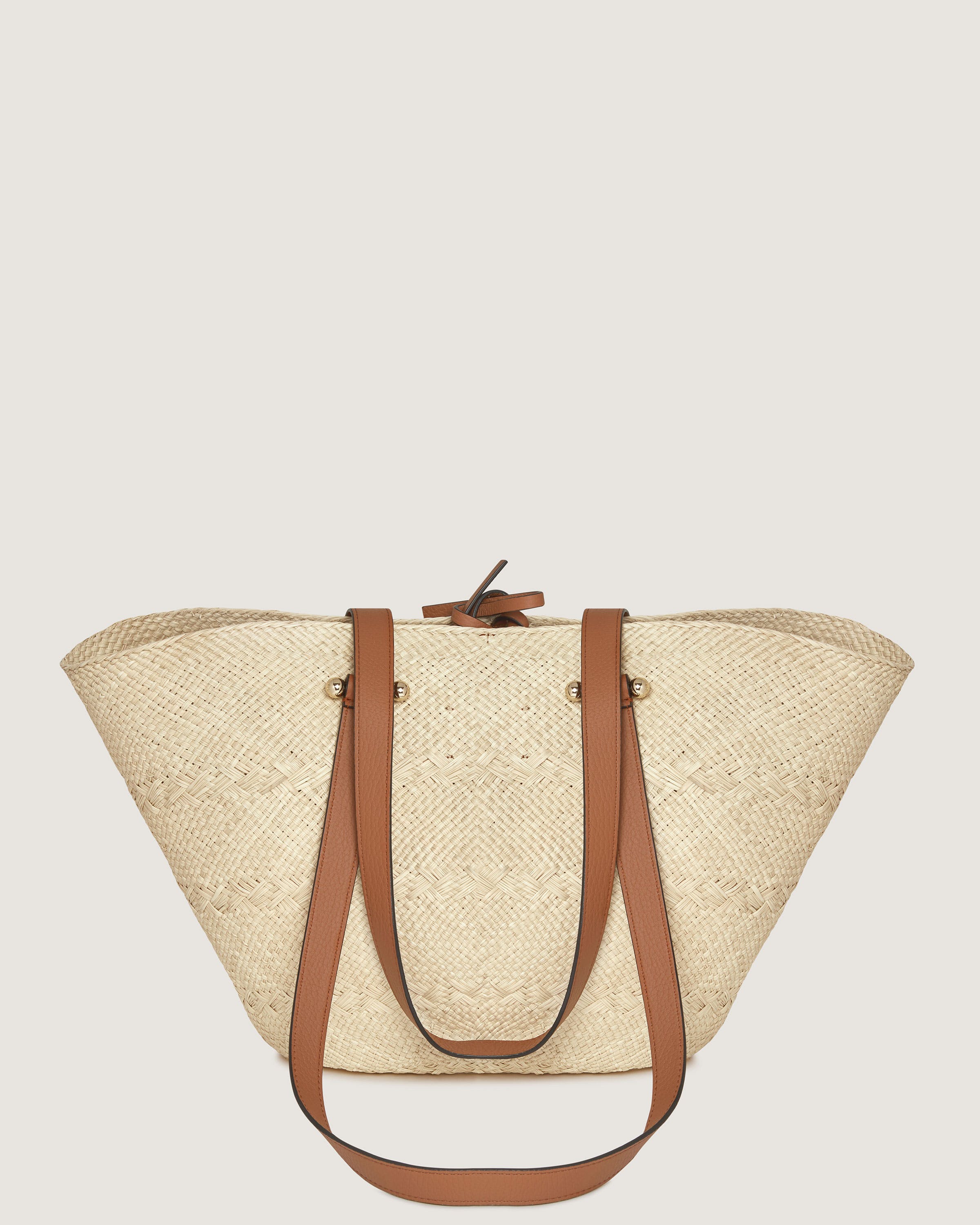 A straw bag with a brown leather handle