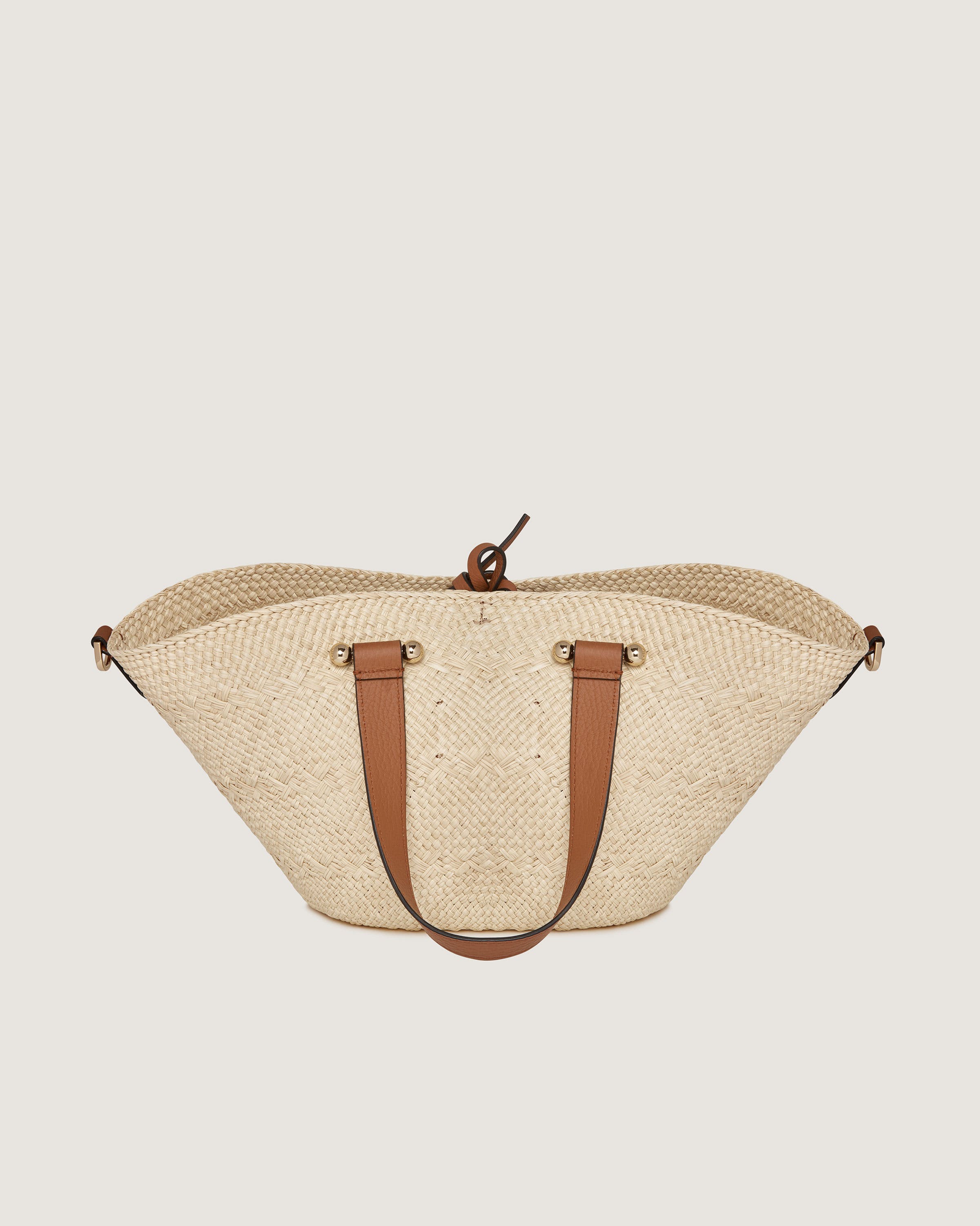 A straw bag with a brown leather handle