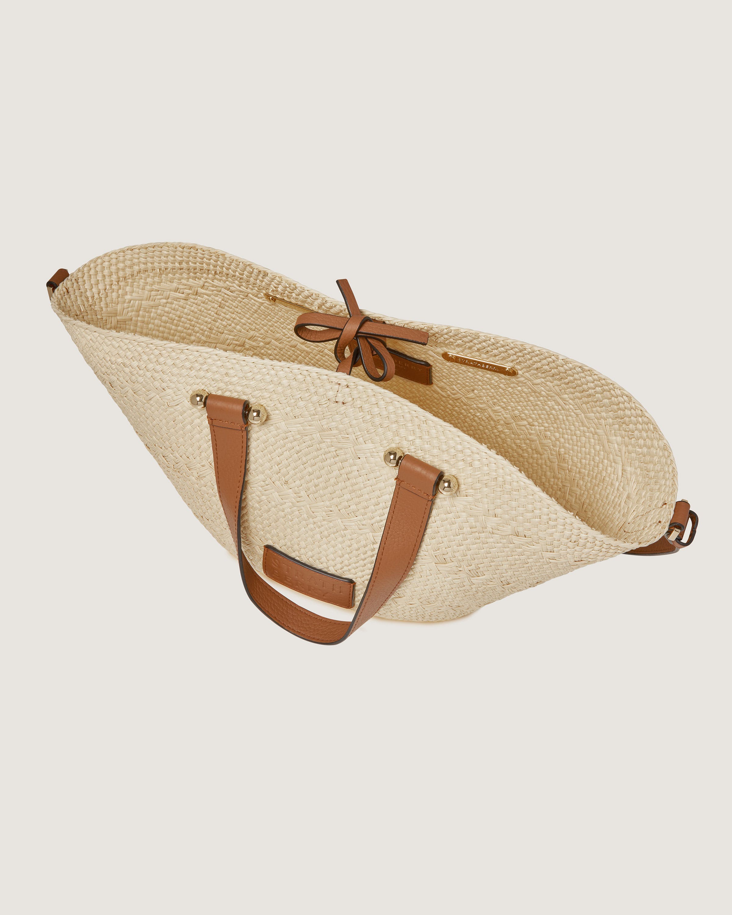 A straw bag with a brown leather strap