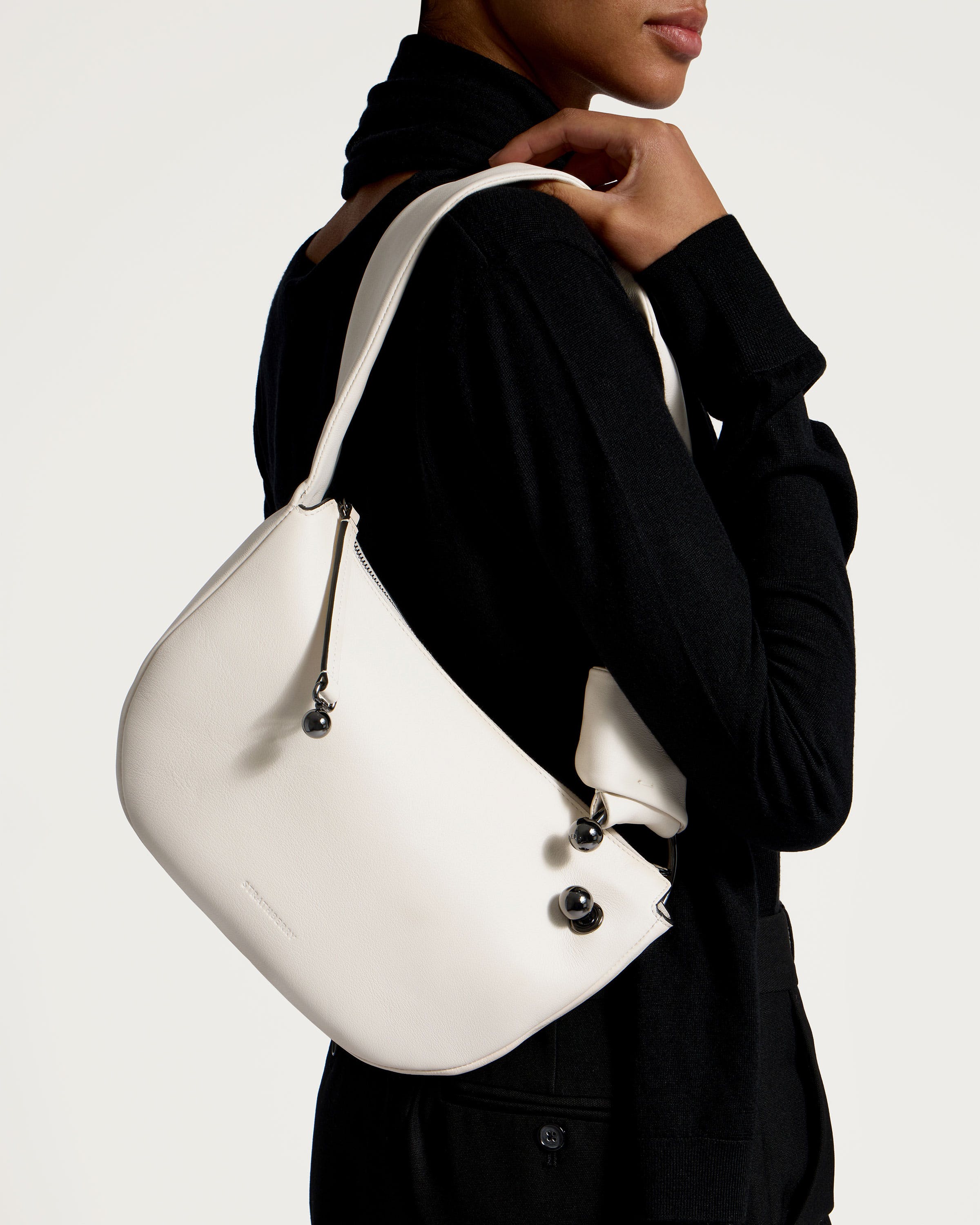 A woman is holding a white purse