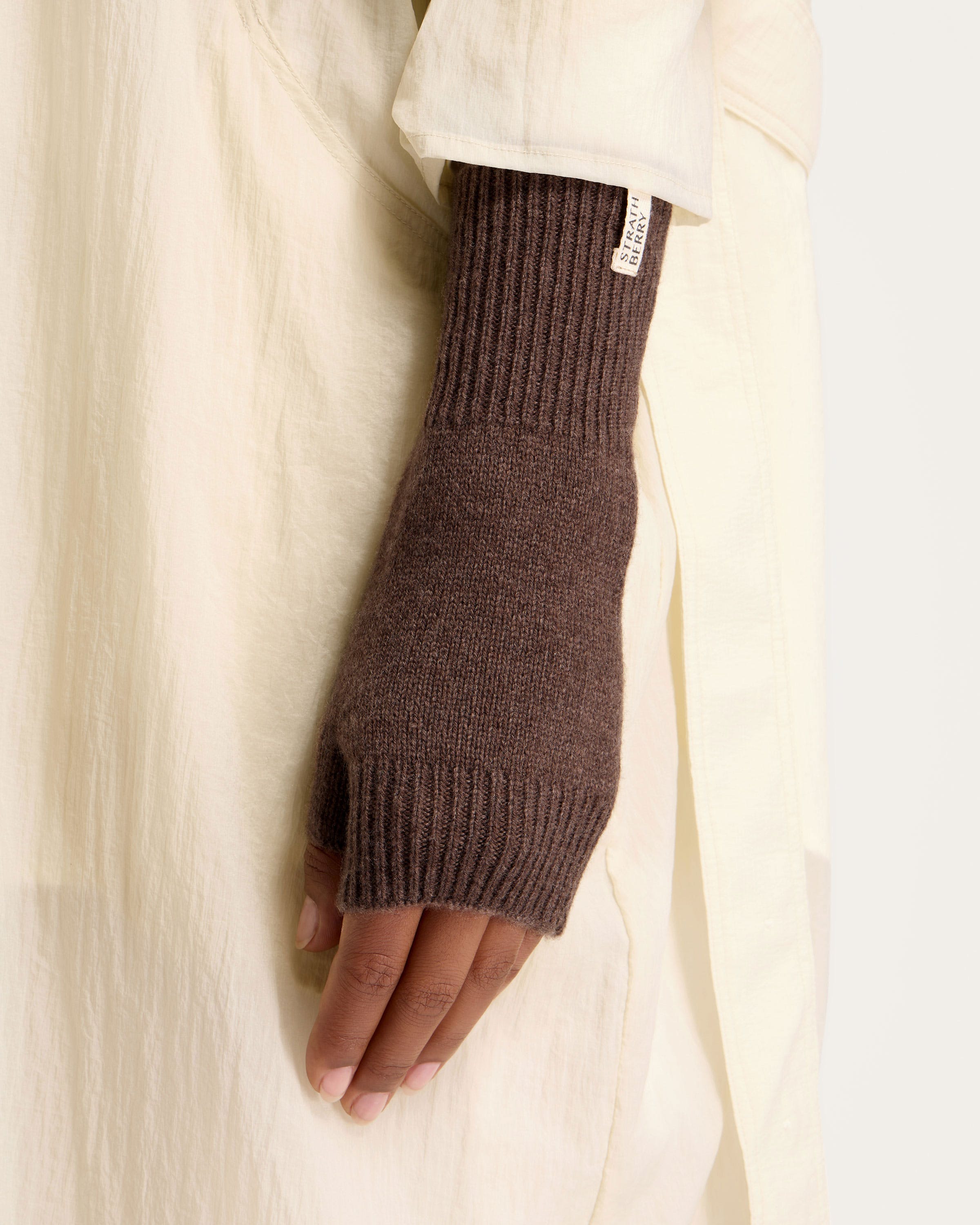 A person wearing a brown knitted arm warmer