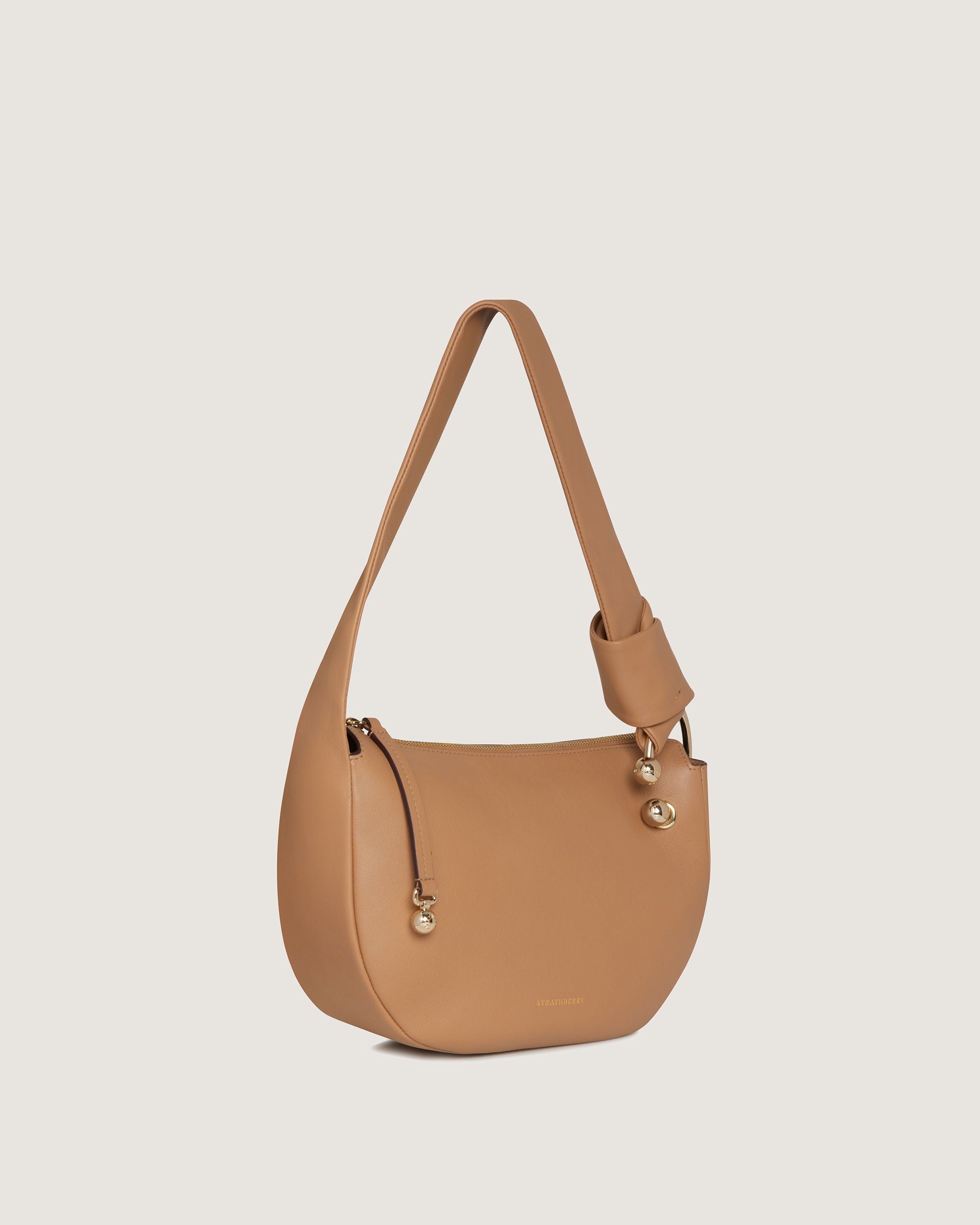 A tan handbag with a shoulder strap