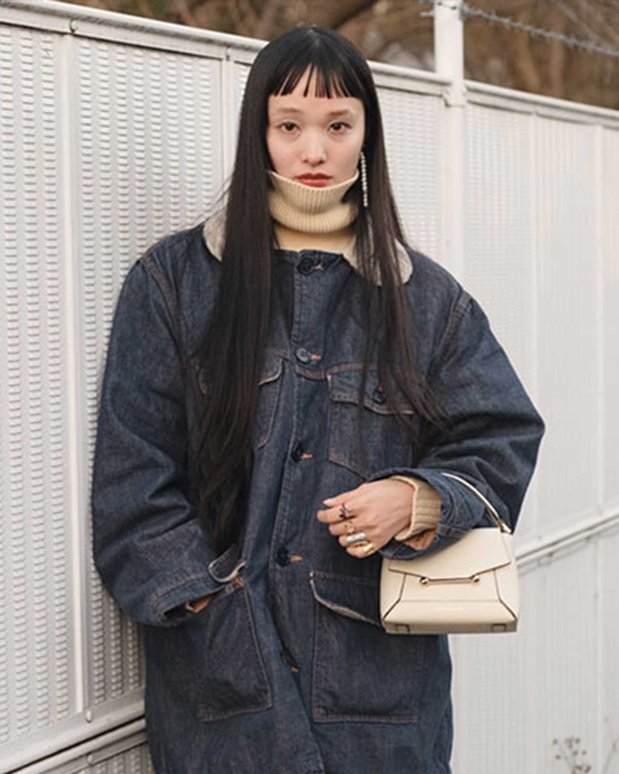 A woman standing next to a white fence