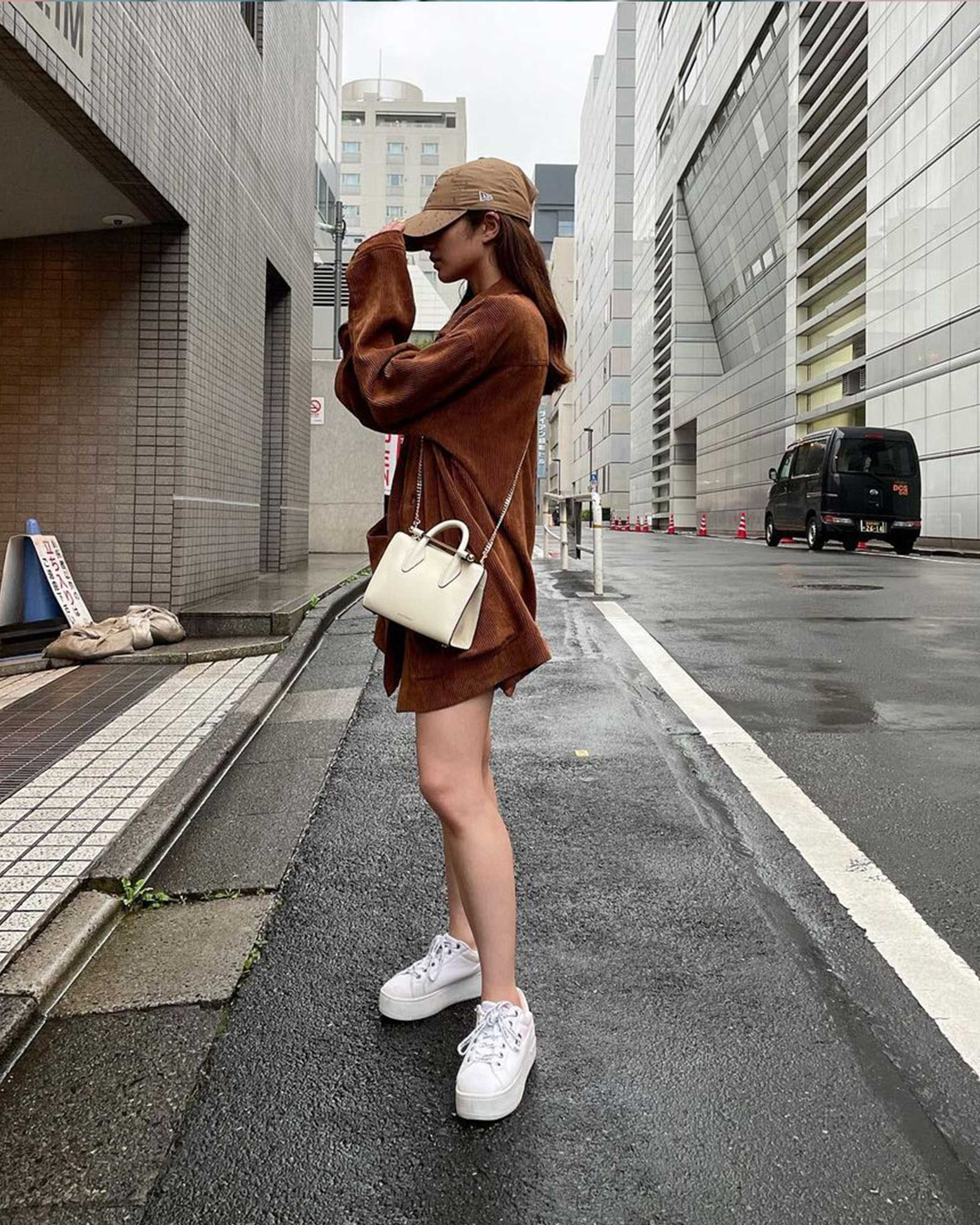 A woman standing on the side of a road