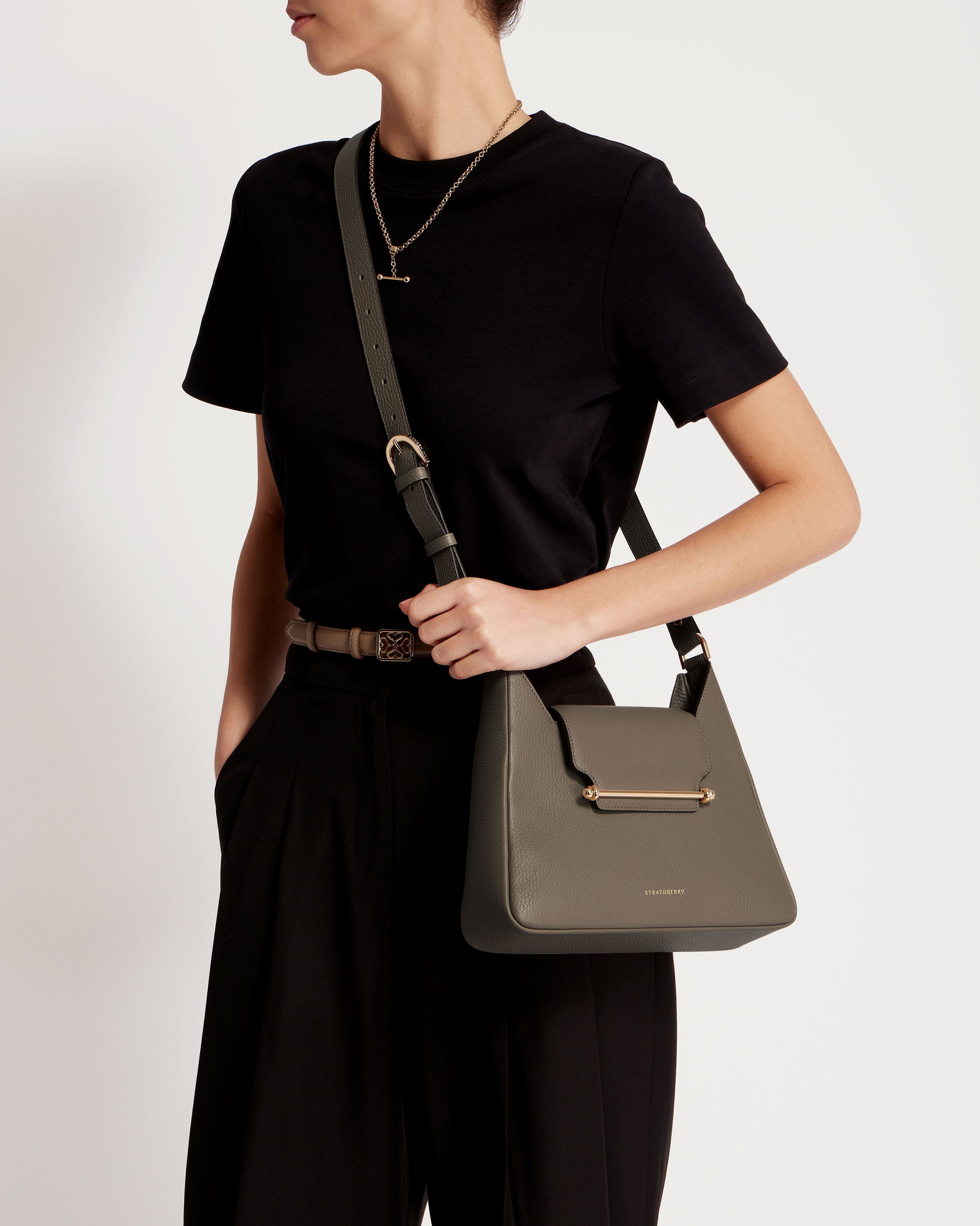 A woman is holding a gray handbag