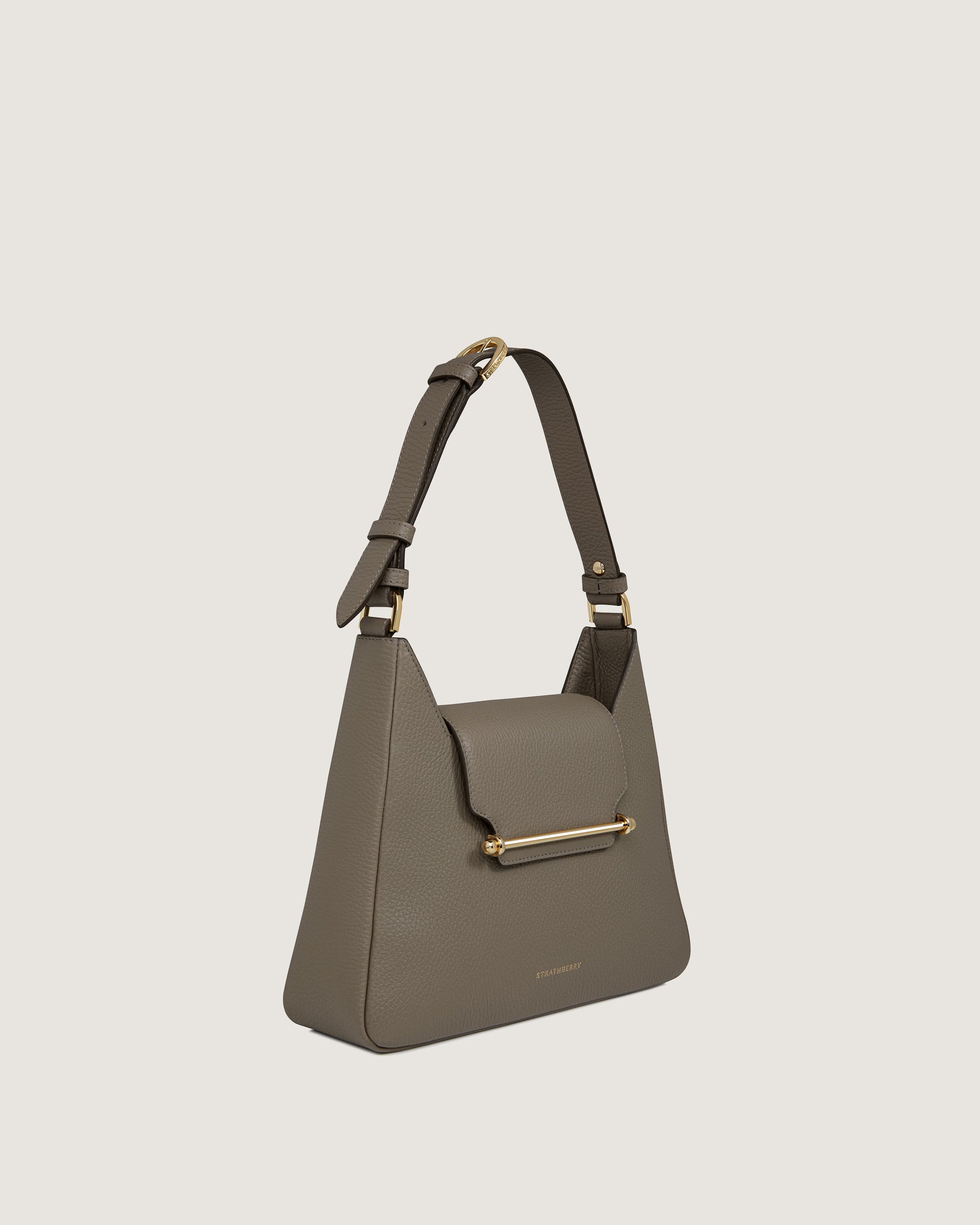 A grey handbag with a gold handle