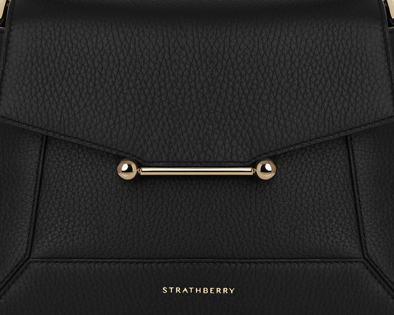 A black handbag with a gold handle