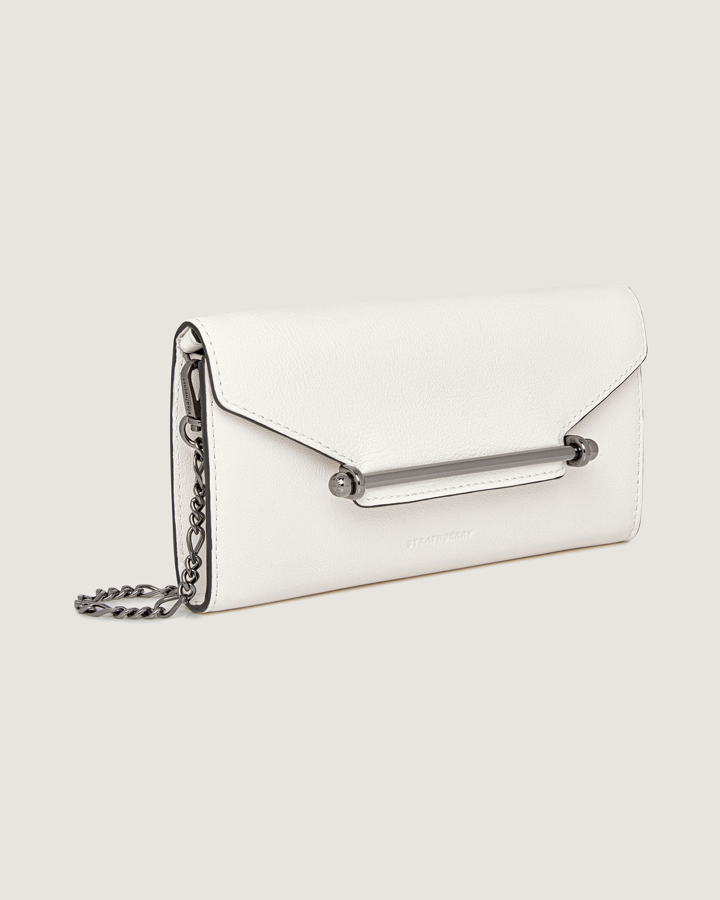 A white purse with a chain hanging from it