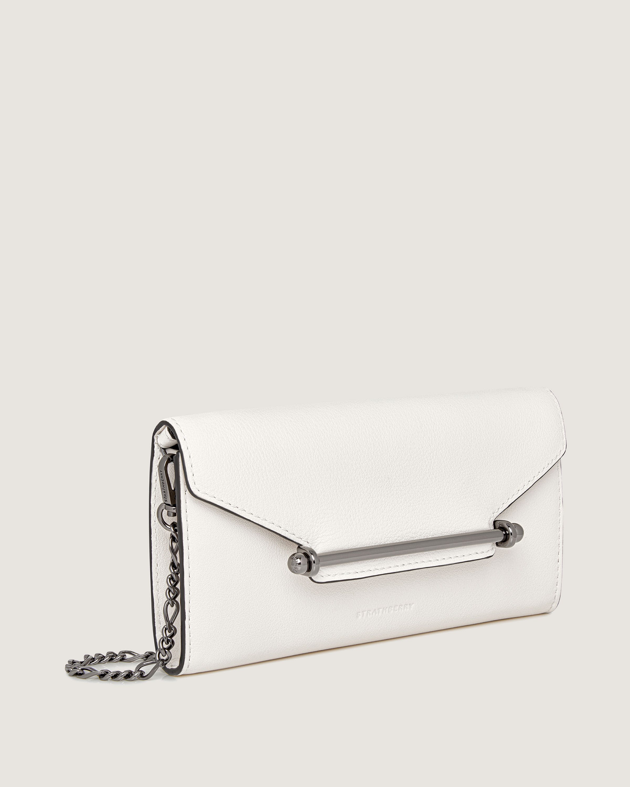 A white purse with a chain hanging from it