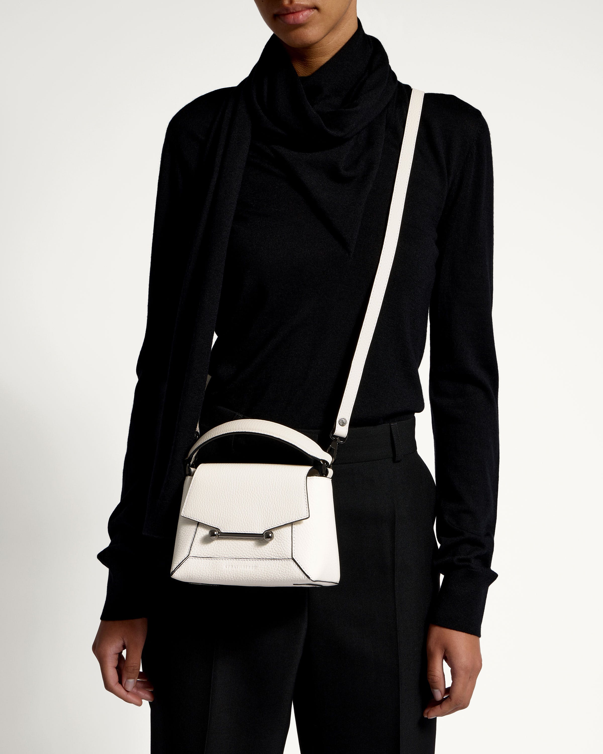 A woman wearing a black shirt and a white purse