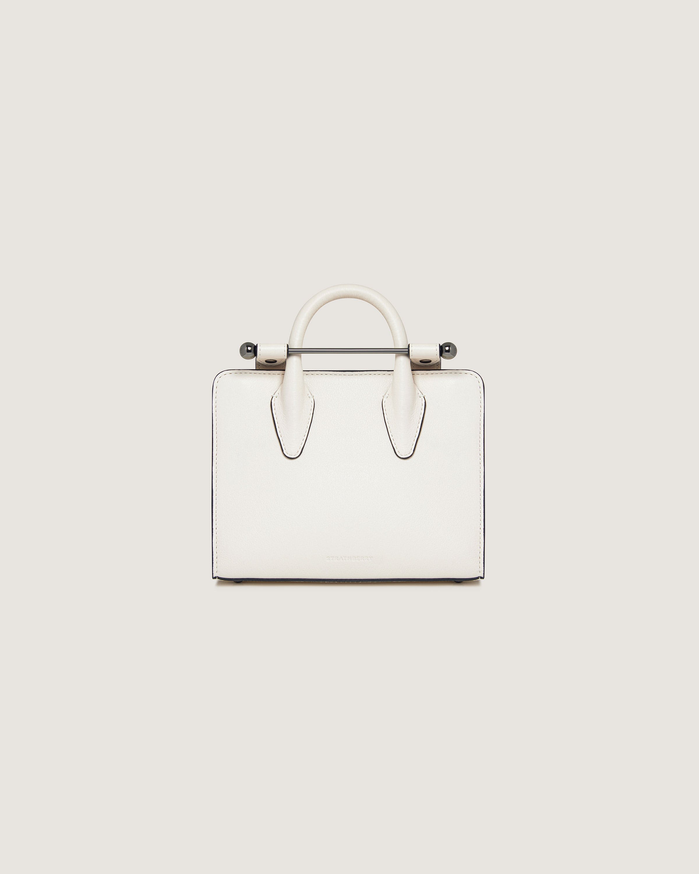 A white handbag with two handles on a white background