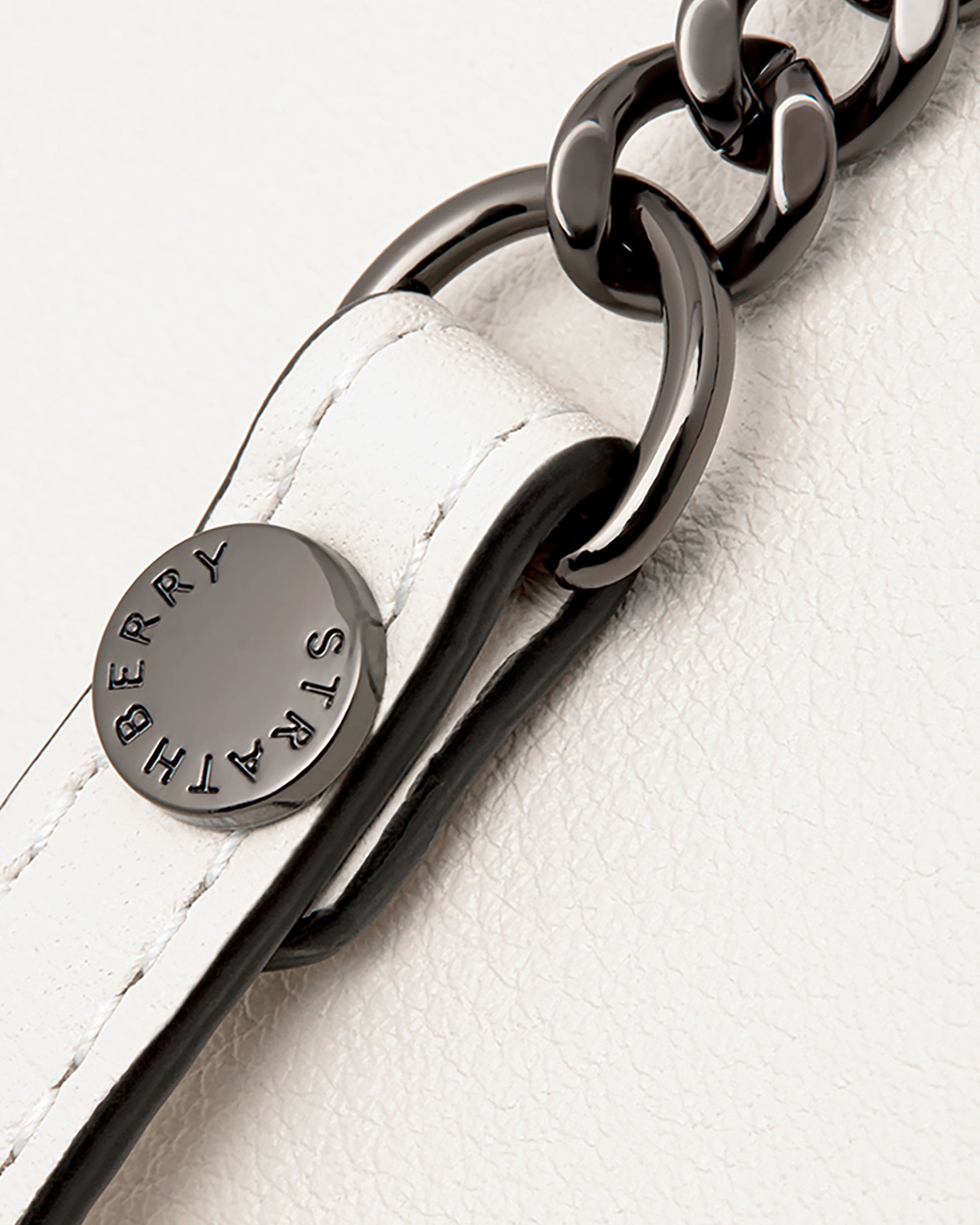 A close up of a white leather key chain