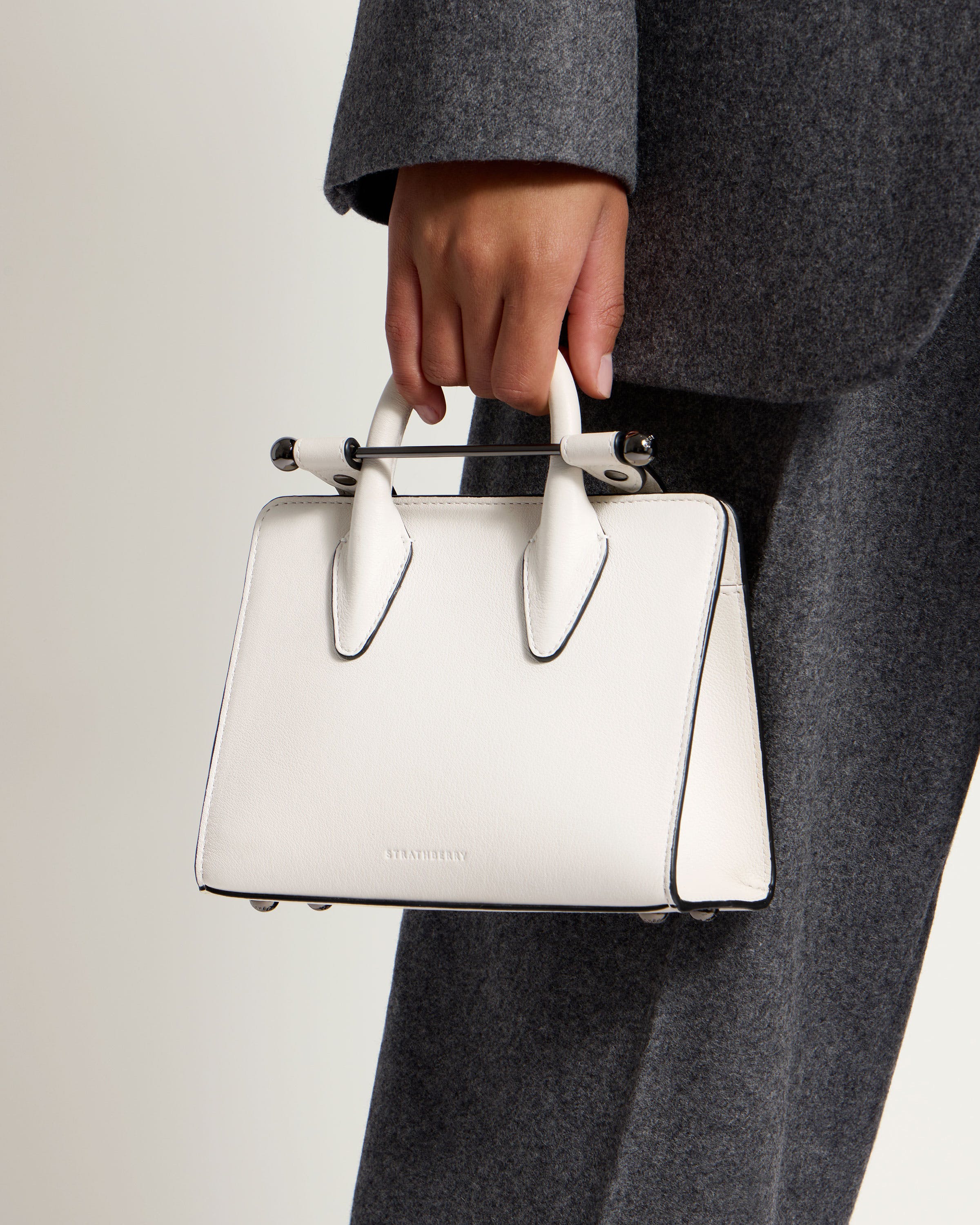 A person holding a white purse in their hand