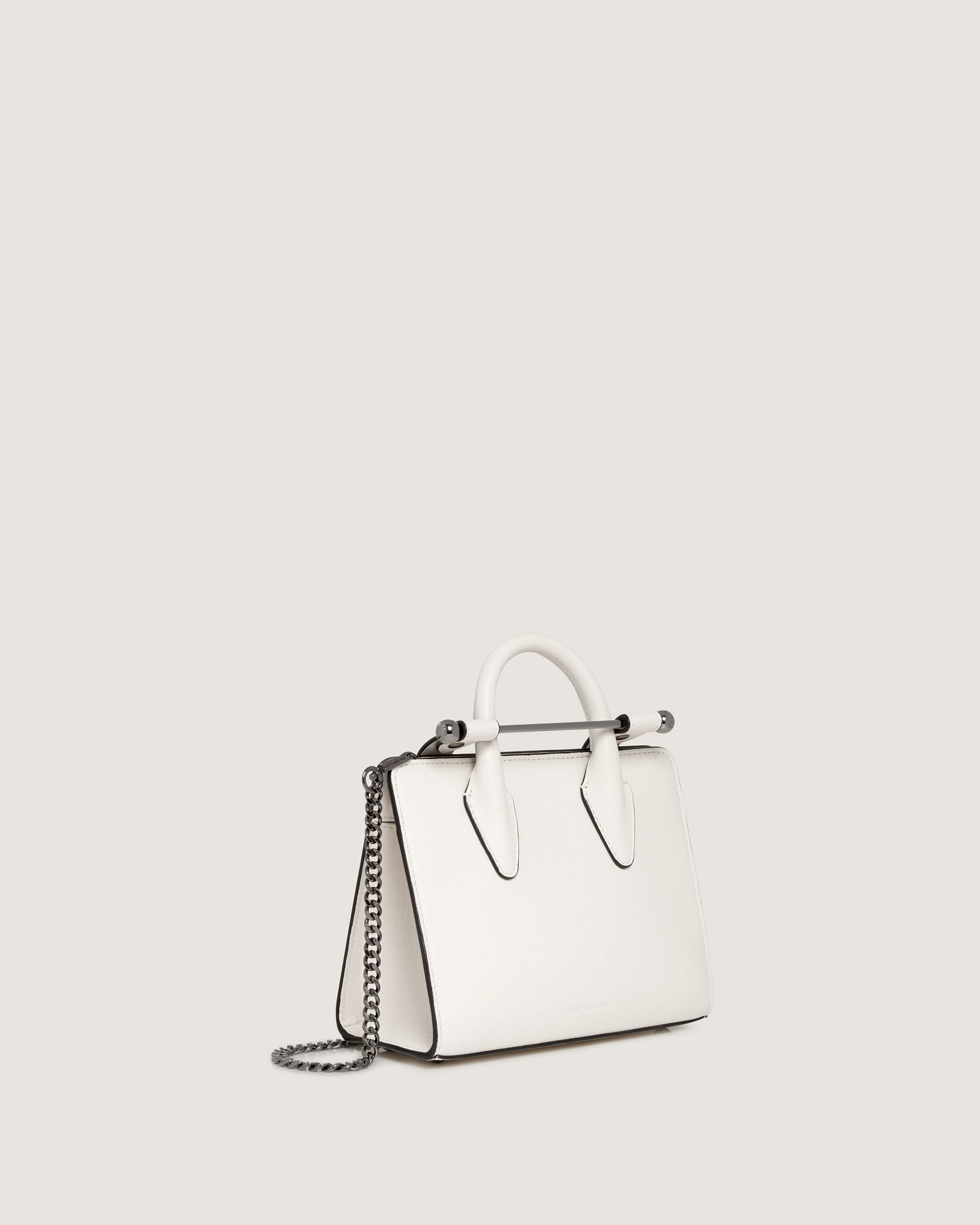 A white handbag with a chain hanging from it