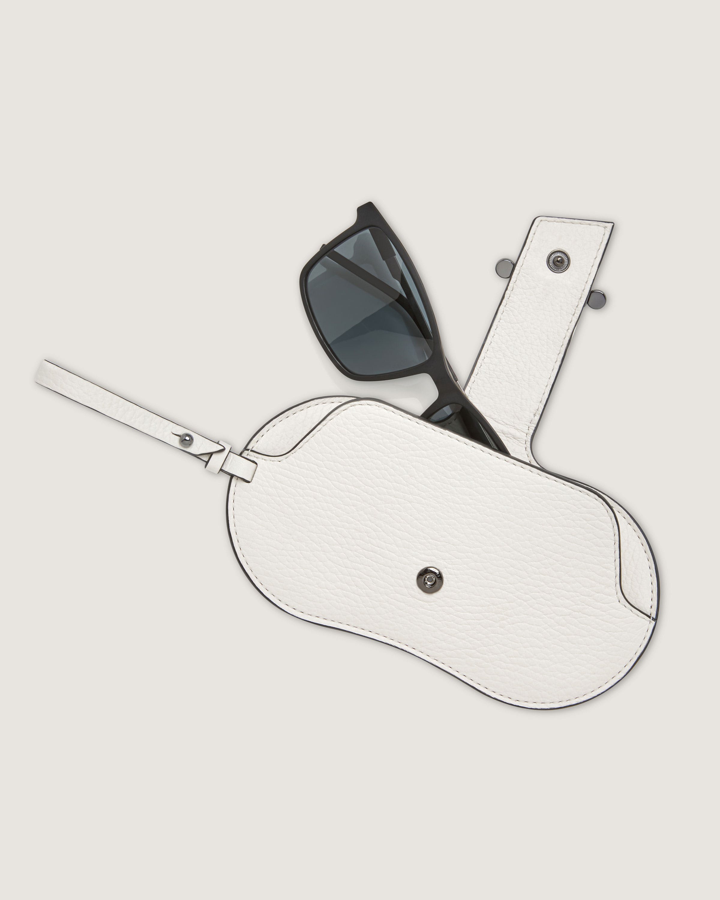 A pair of sunglasses sitting on top of a white case