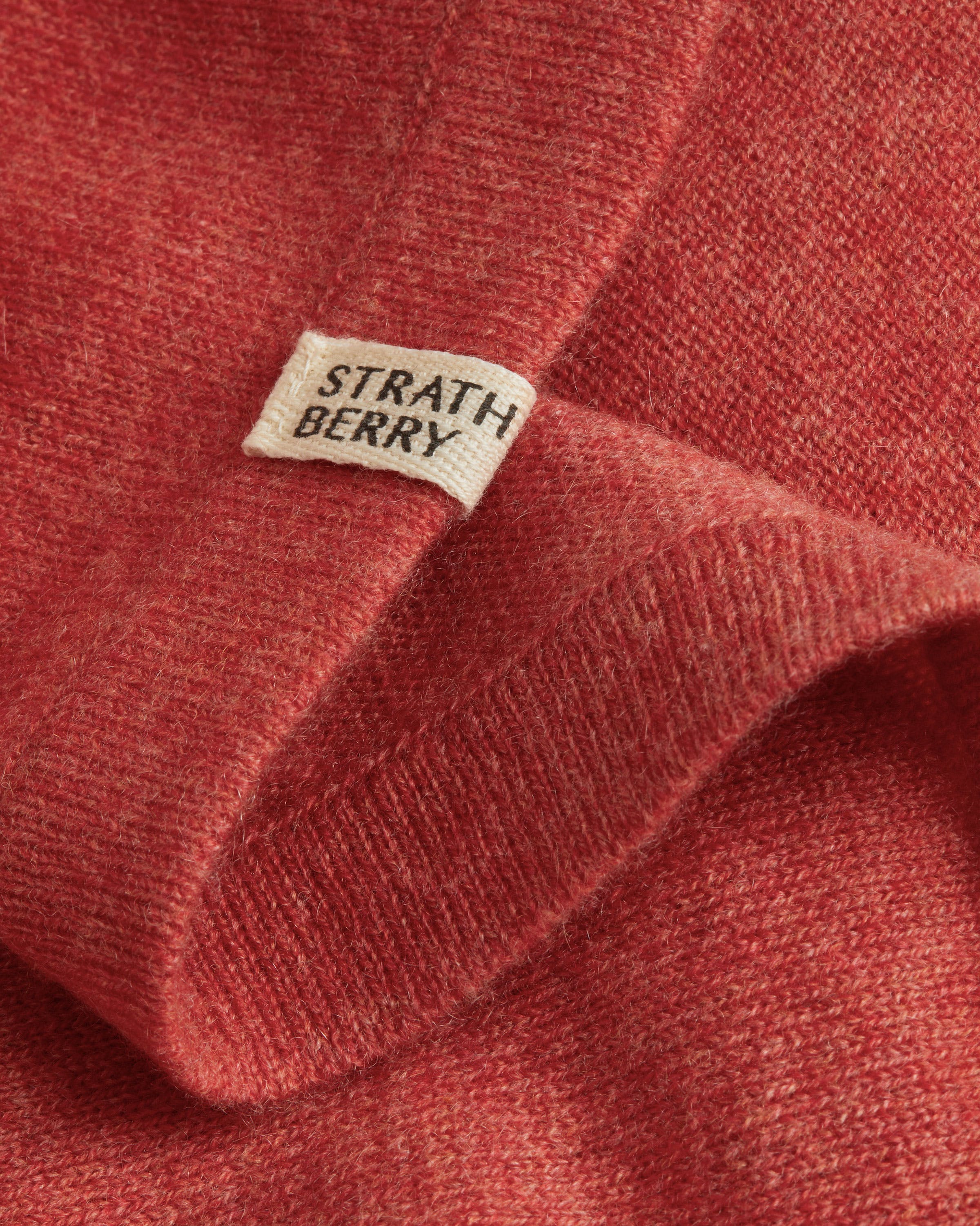 A label on a red sweater that says, strath berry