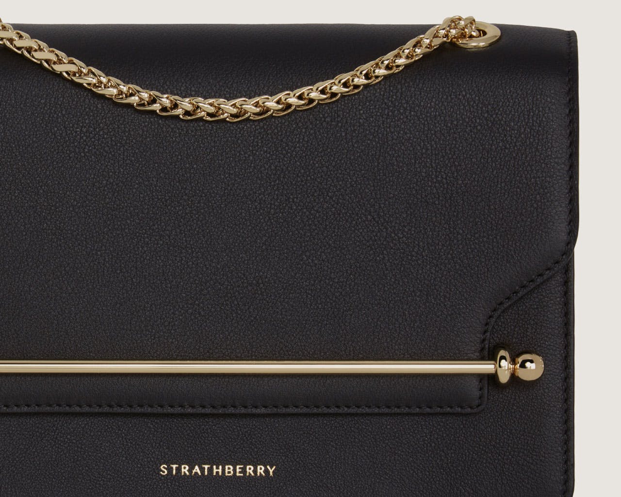 A black handbag with a gold chain strap