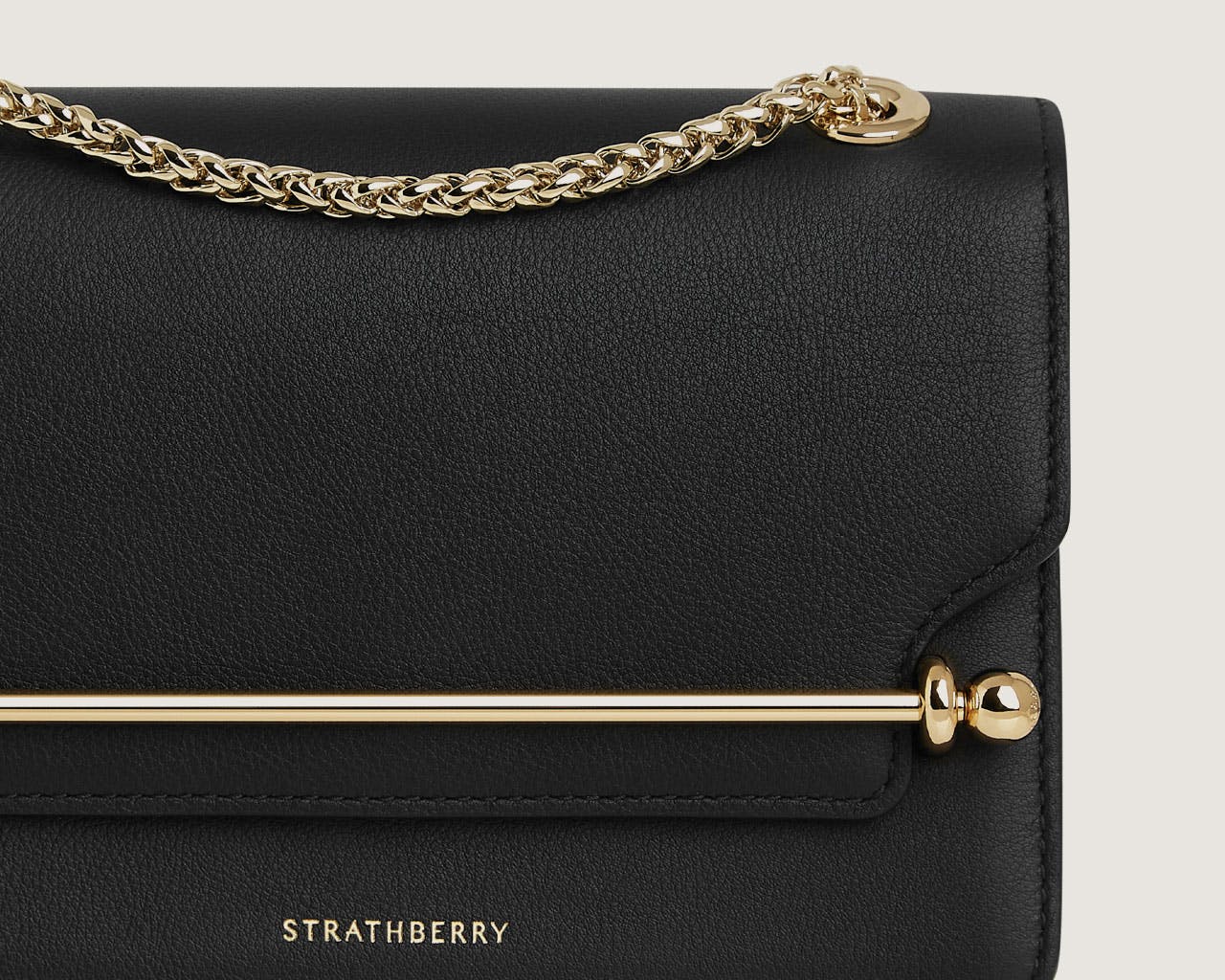 A black handbag with a gold chain strap