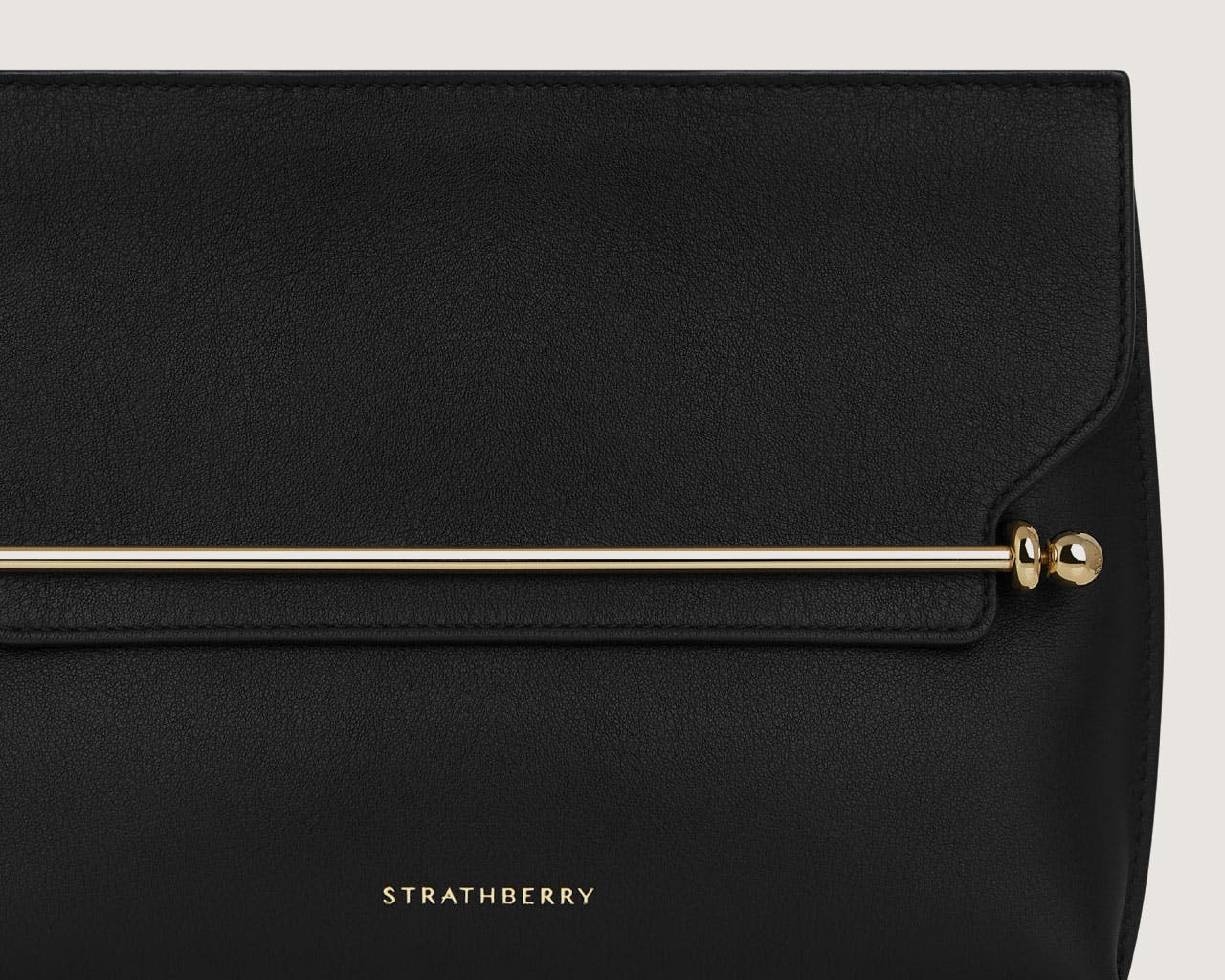 A black handbag with a gold handle