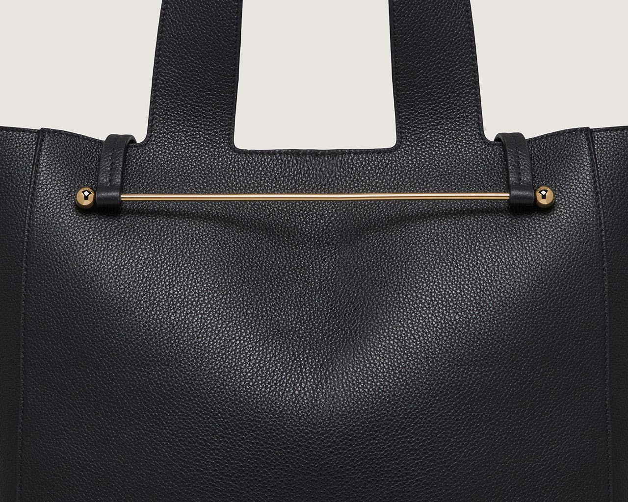 A black handbag with a gold handle