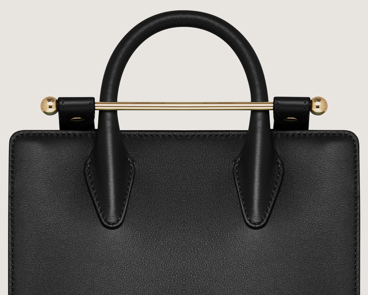 A black handbag with a gold handle