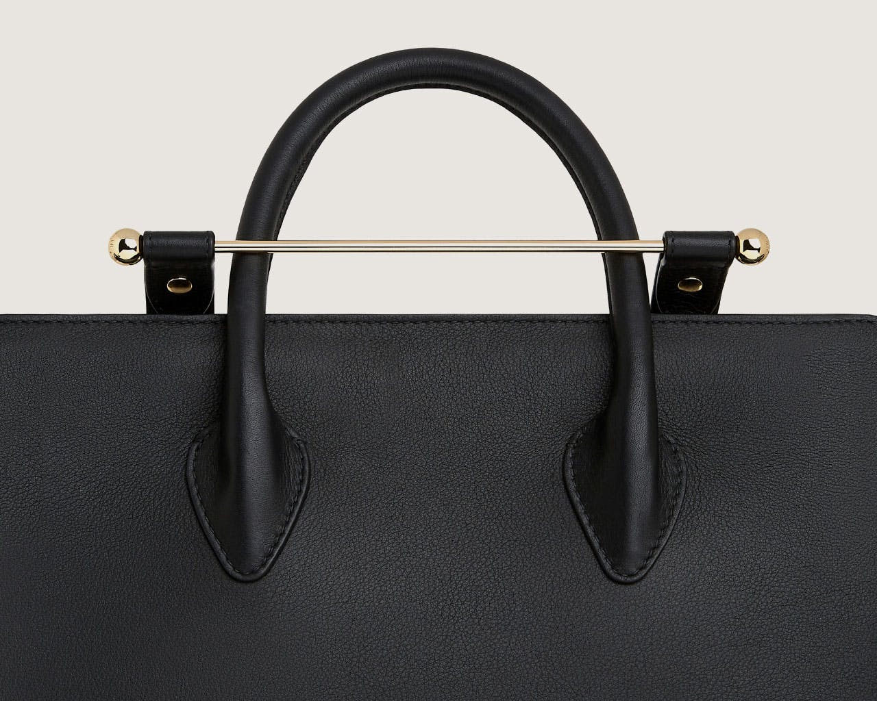 A black handbag with a gold handle